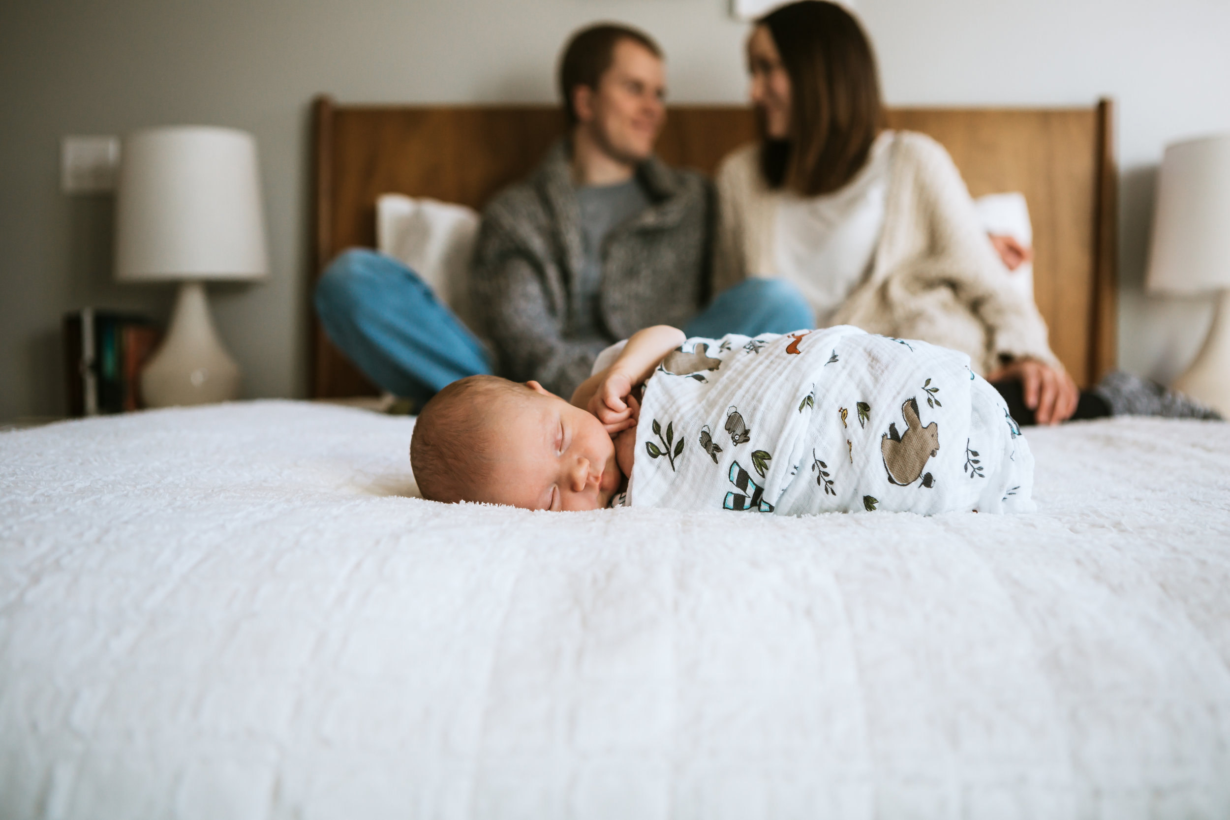 Mom and dad in the background sitting on the bed while baby sleeps front and center #tealawardphotography #texasfamilyphotographer #amarillophotographer #amarillofamilyphotographer #lifestylephotography #emotionalphotography #familyphotosoot #family #lovingsiblings #purejoy #familyphotos #howtoprepare #naturalfamilyinteraction #10tips