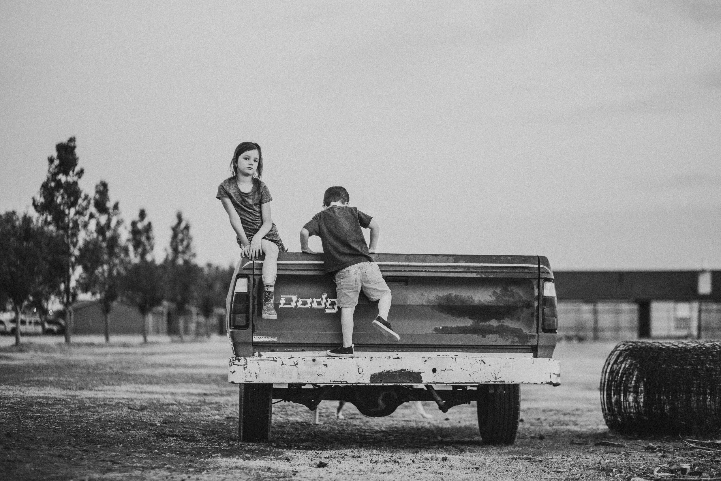  Little one climbs into the truck along with this sister in this black and white timeless photo #tealawardphotography #texasfamilyphotographer #amarillophotographer #amarillofamilyphotographer #lifestylephotography #fallphotos #familyphotoshoot #family #lovingsiblings #photographytips #familyphotos #naturalfamilyinteraction 