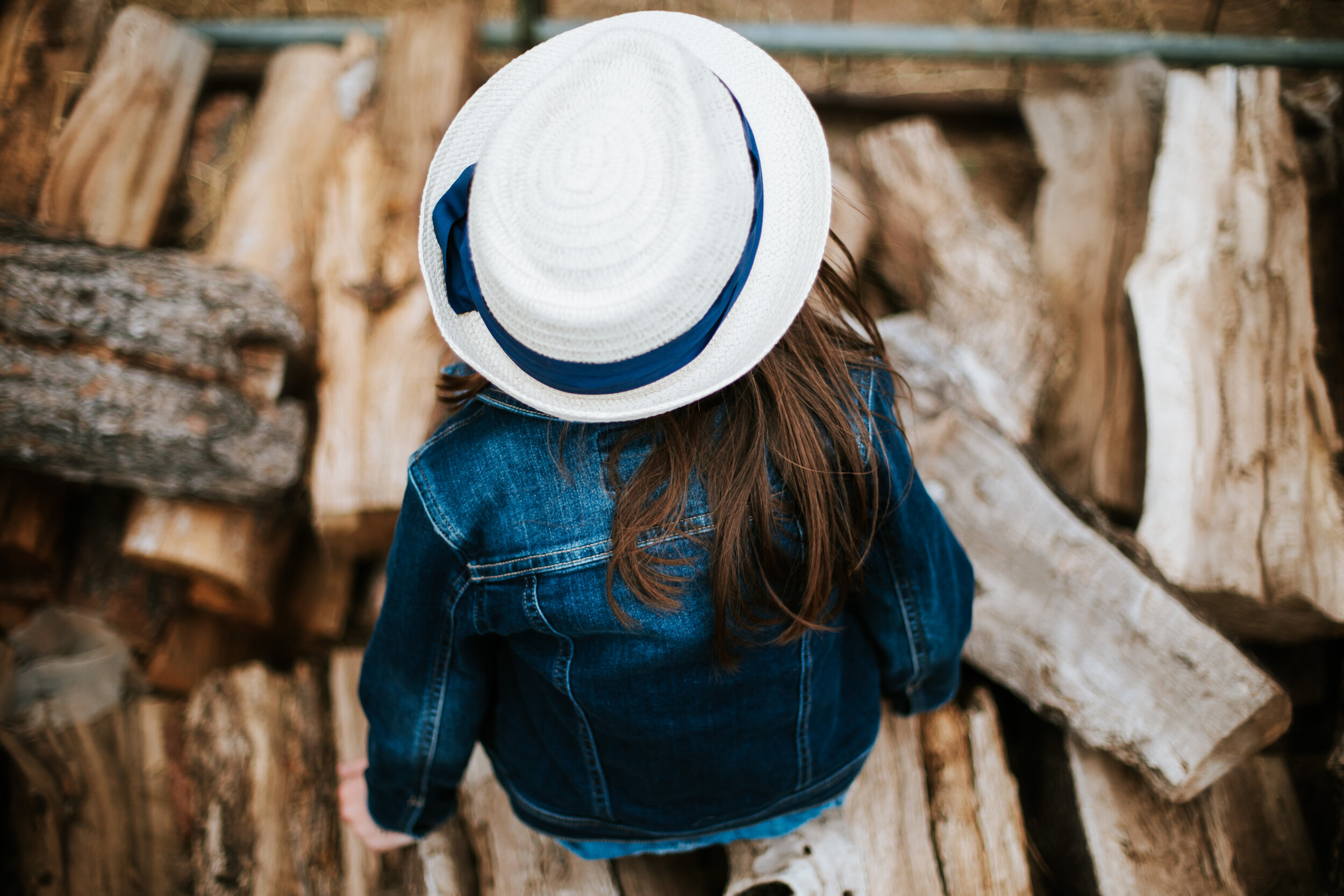  Little girl in a blue coat and white hat gazing at the firewood pile that would soon be needed as the air chills #tealawardphotography #texasfamilyphotographer #amarillophotographer #amarillofamilyphotographer #lifestylephotography #fallphotos #familyphotoshoot #family #lovingsiblings #photographytips #familyphotos #naturalfamilyinteraction 
