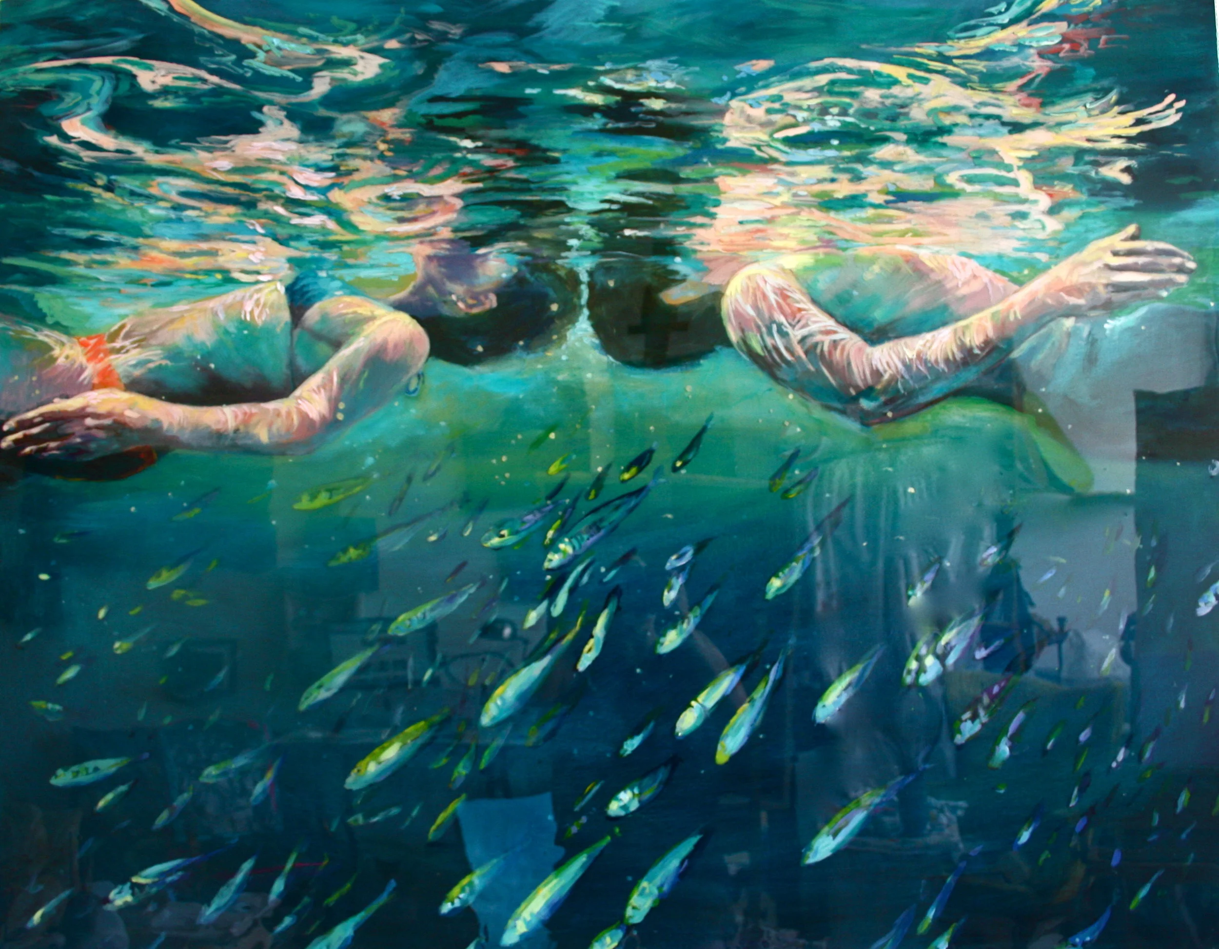Two people swimming underwater with small fish swimming beneath them.