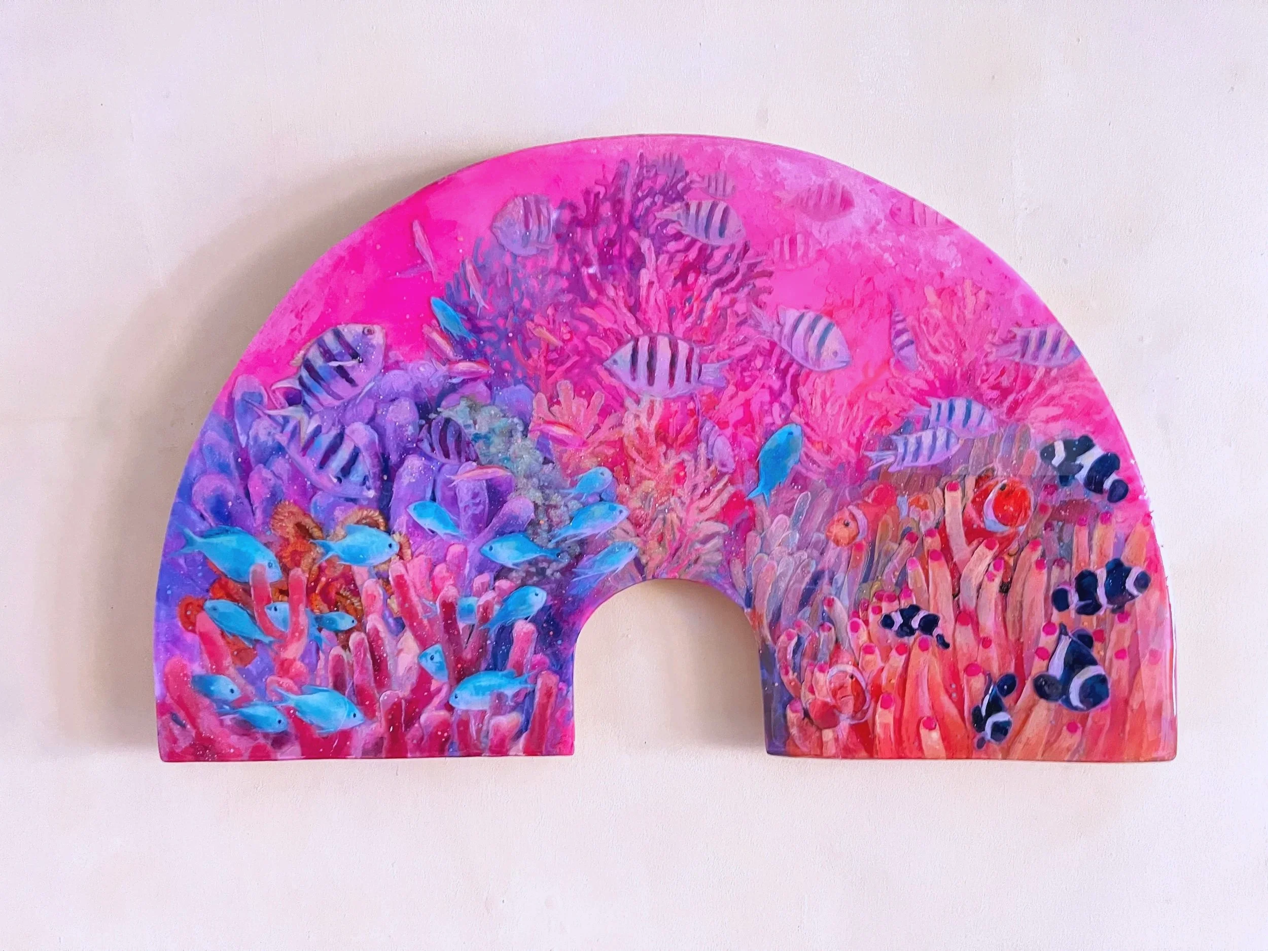 Decorative piece resembling a rainbow made with colorful underwater coral and fish patterns in vibrant pink, purple, and blue tones.