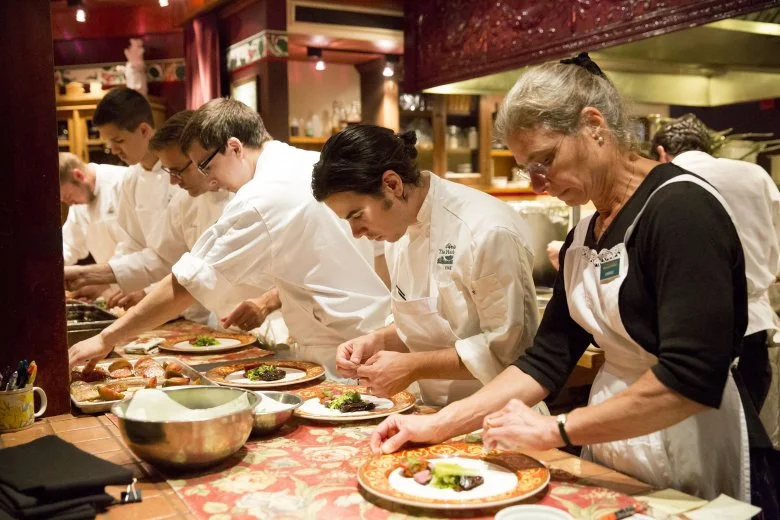 The Herbfarm’s co-owner Carrie Van Dyck, right, and chef Chris Weber (to Van Dyck’s right) plate one of the evening’s nine courses. Courtesy of Erika Schultz / The Seattle Times