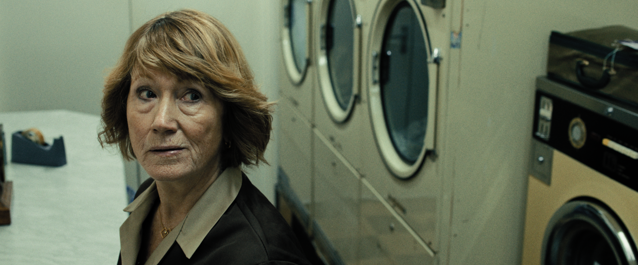 Female launderette owner stares up at cctv