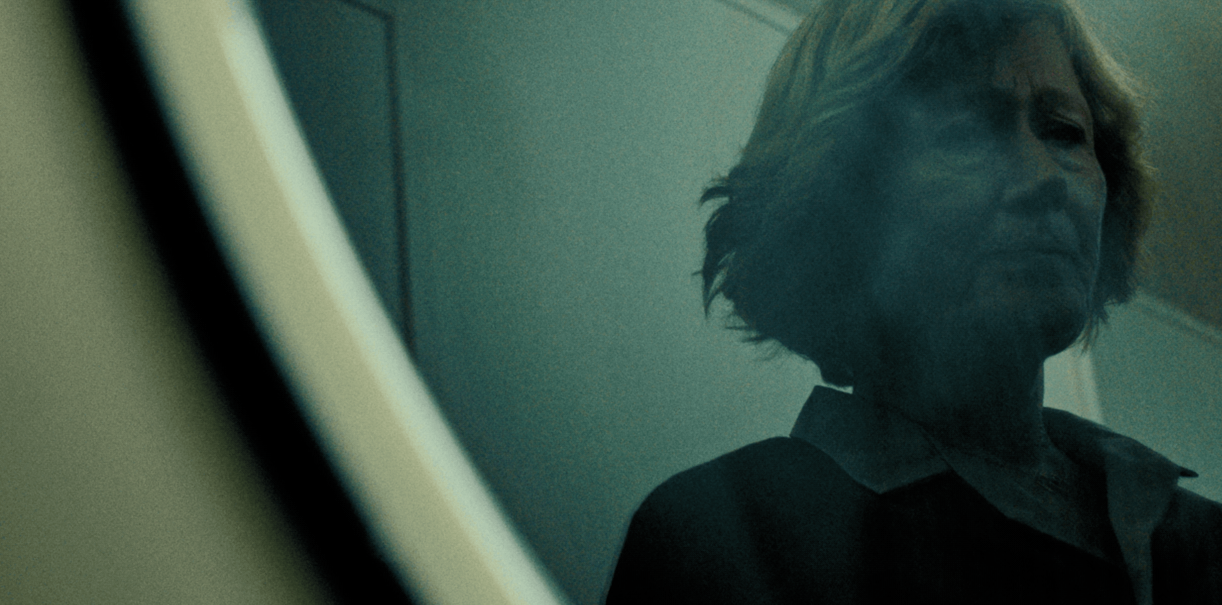 Disturbing reflection of a woman staring into the drum of a washing machine