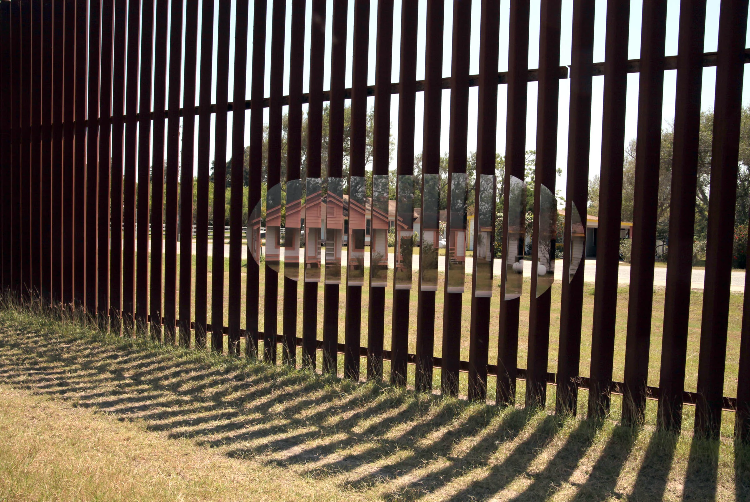 "Pink House on Wall" Photograph of installation, wheat pasted photograph on border wall Variable Dimensions 2017