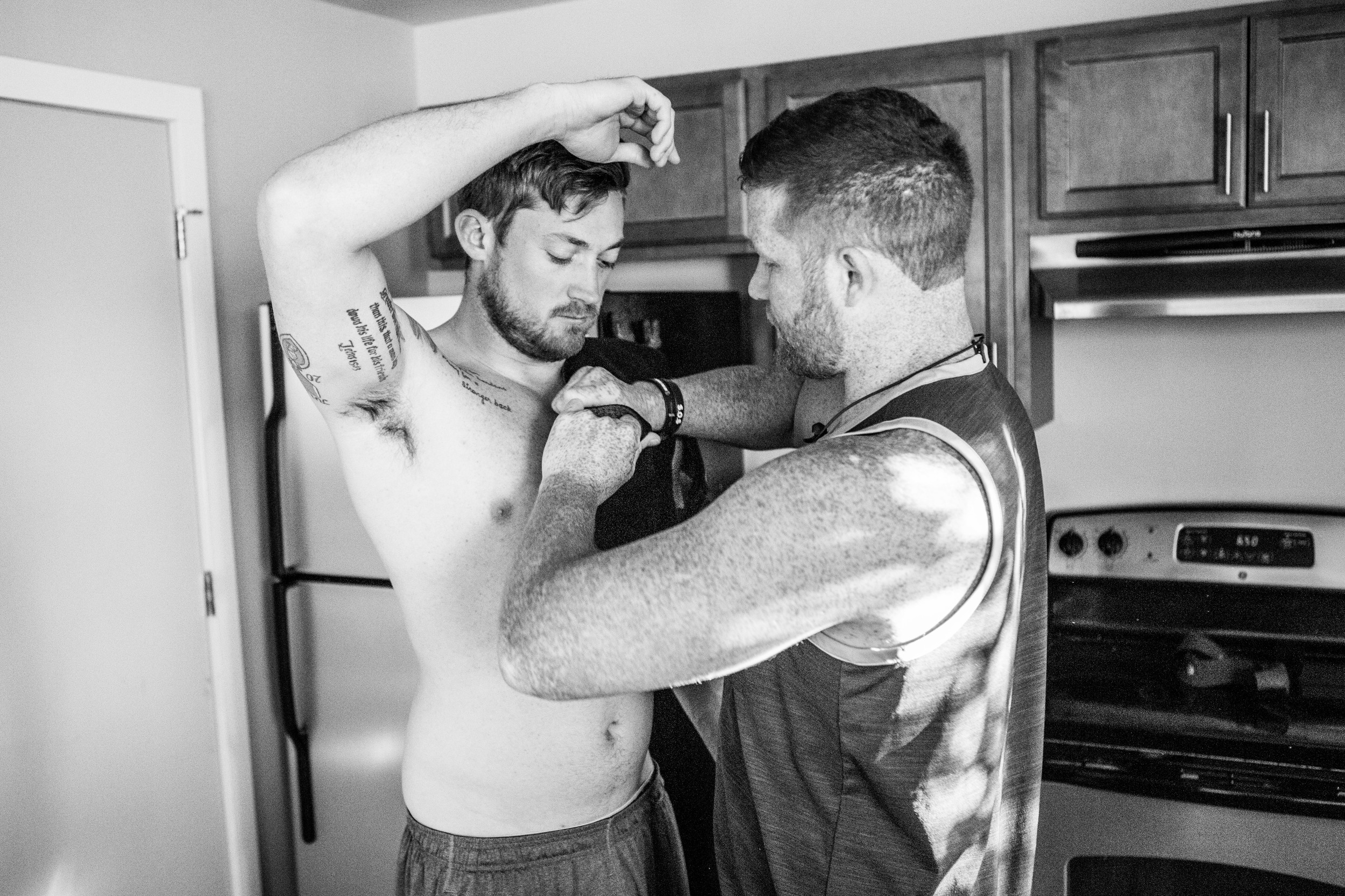 Evan's friend Justin helps him put on a brace that secures his shoulder while he works out. 