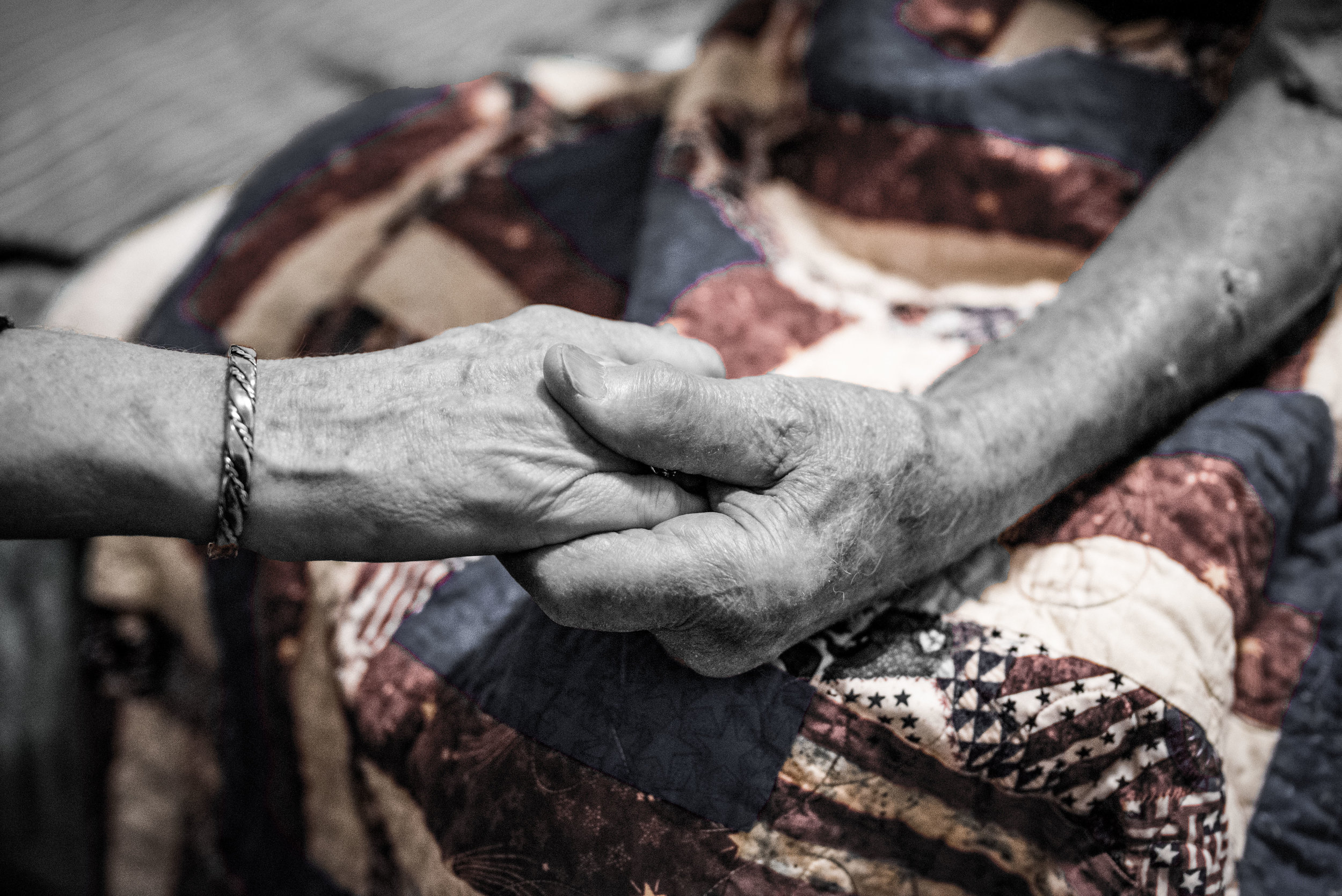 Alfred holds the hand of his daughter, DeLoyce. DeLoyce is instrumental in Alfred's life, as he requires a caretaker for certain needs. 