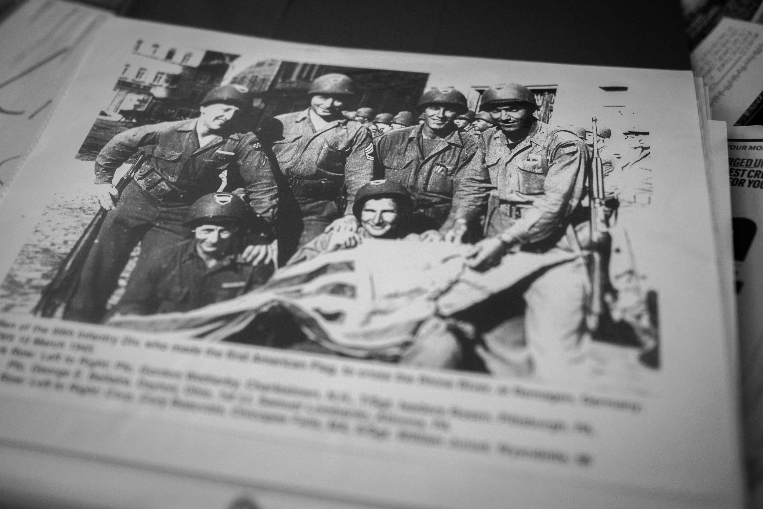 Sam with his men in Germany, holding the flag they'd made after the war had ended.