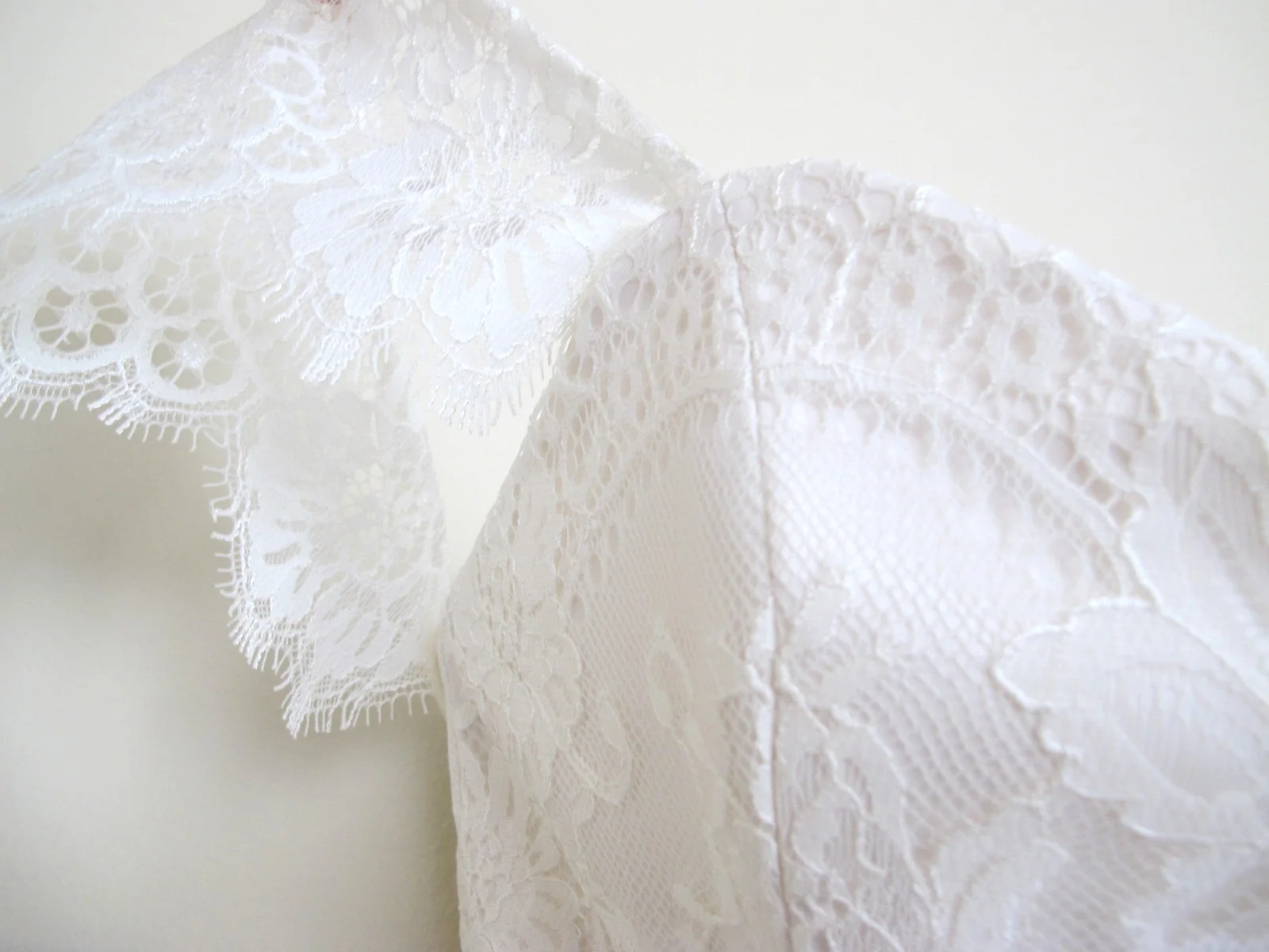 detail of lace bodice with lace flutter sleeve