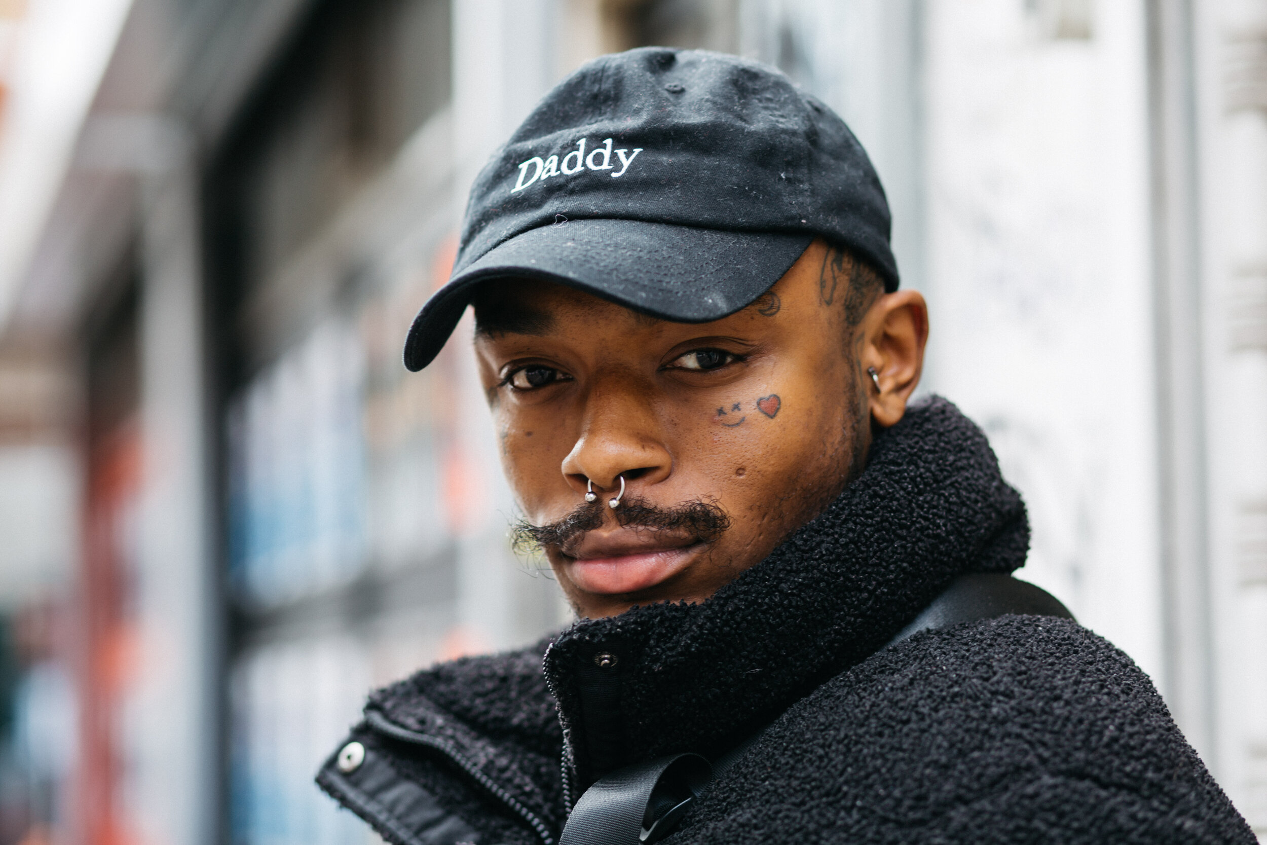 man in black cap on street