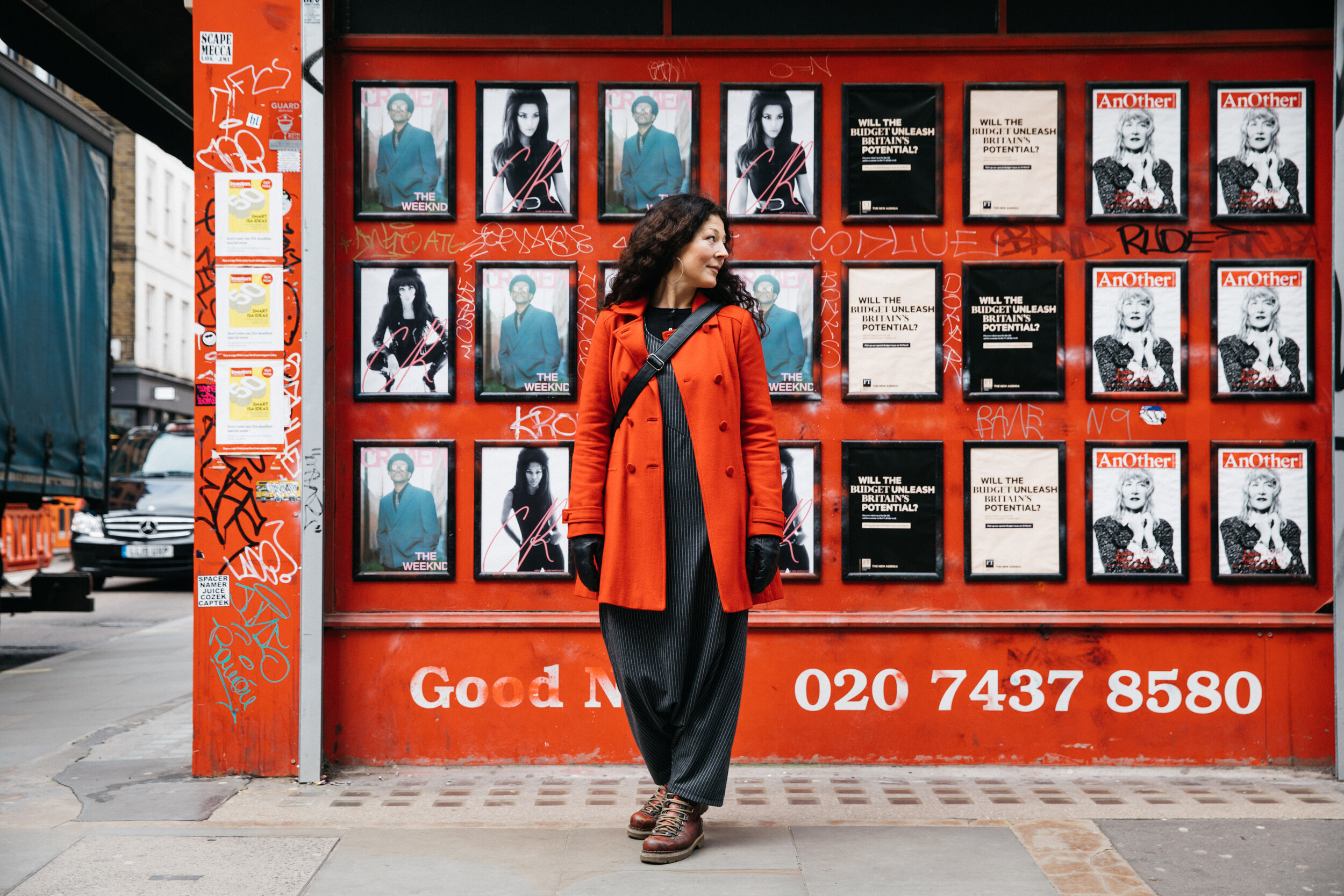 woman in red standing in front of red shop front