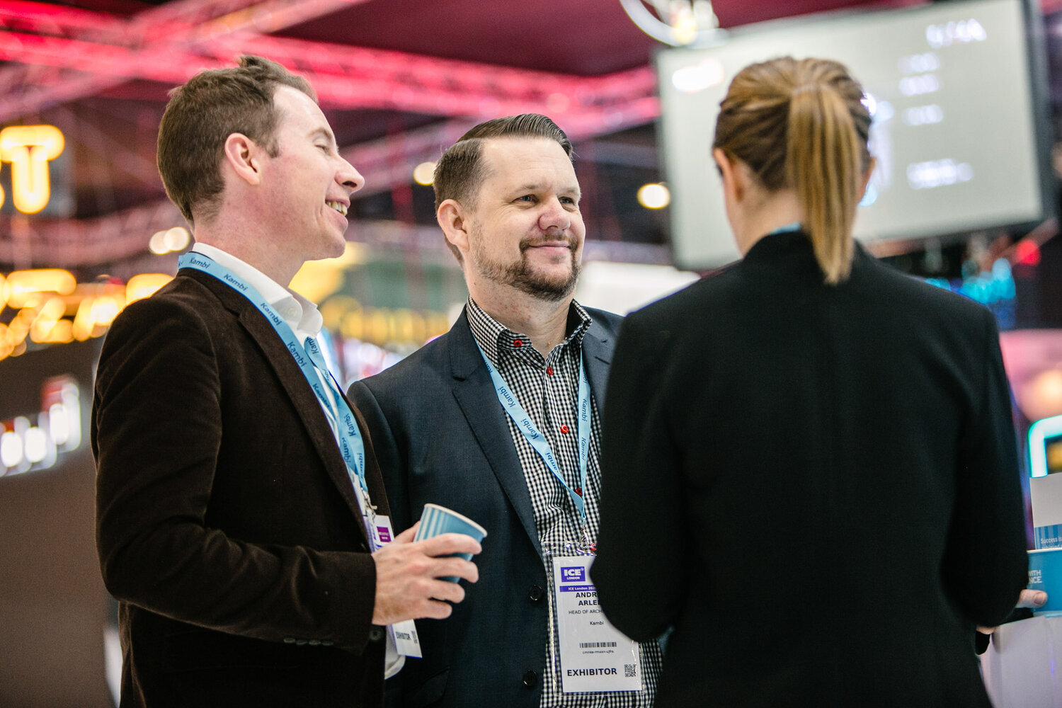 group of three men standing talking at trade show at excel London