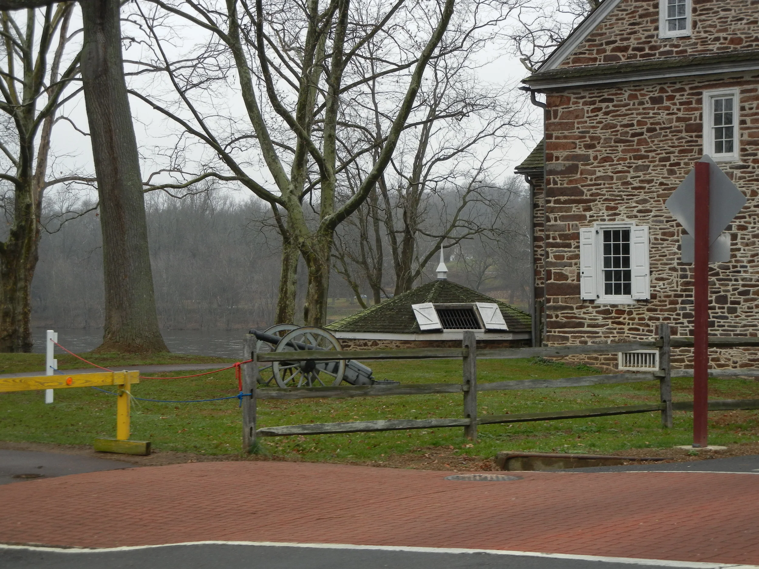 A posted cannon along with periodic housing. The open doors are a refridgerator of sorts during Colonial times.