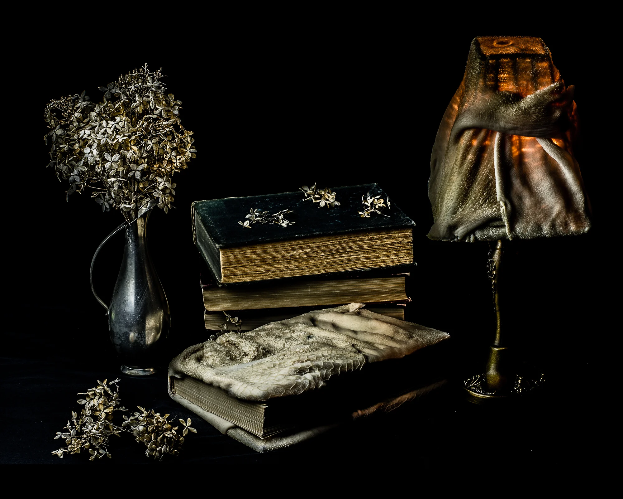 Book bound in sheep stomach with dead flowers and sheep stomach lampshade.