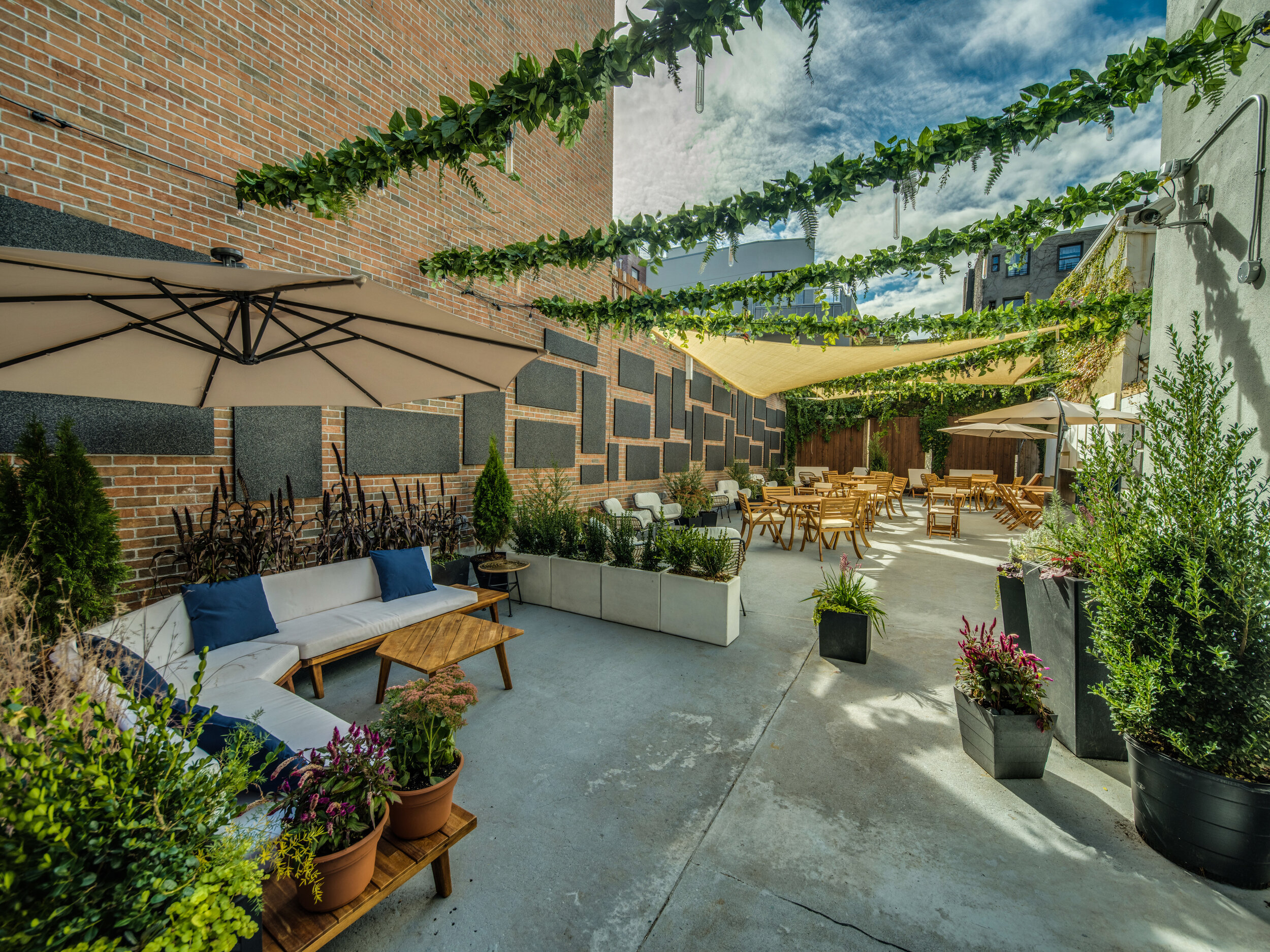 Sun-drenched outdoor patio with ample seating and a relaxed ambiance. Photo Credit - Oleg March
