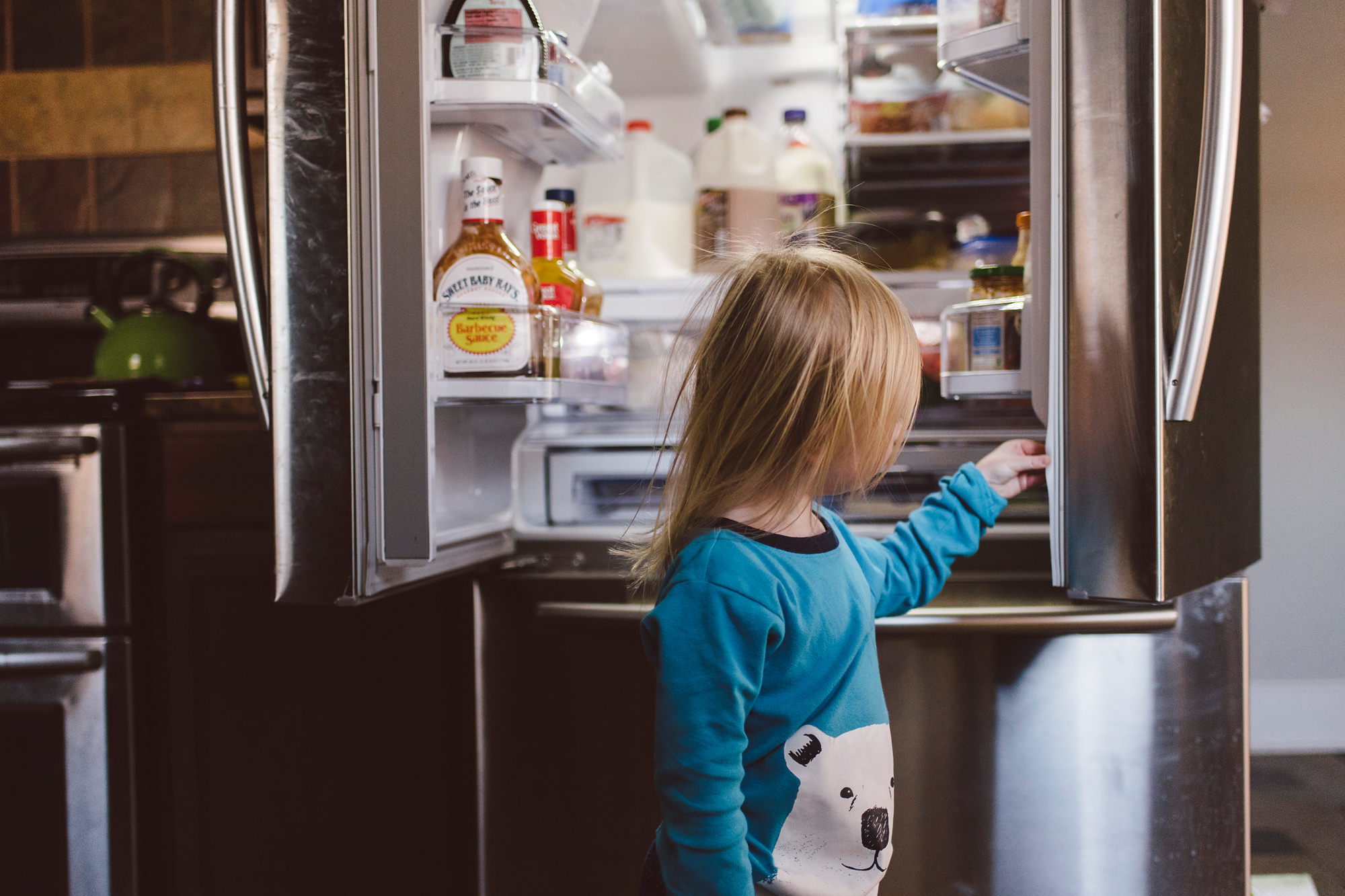 Little girl looking in refridgerator