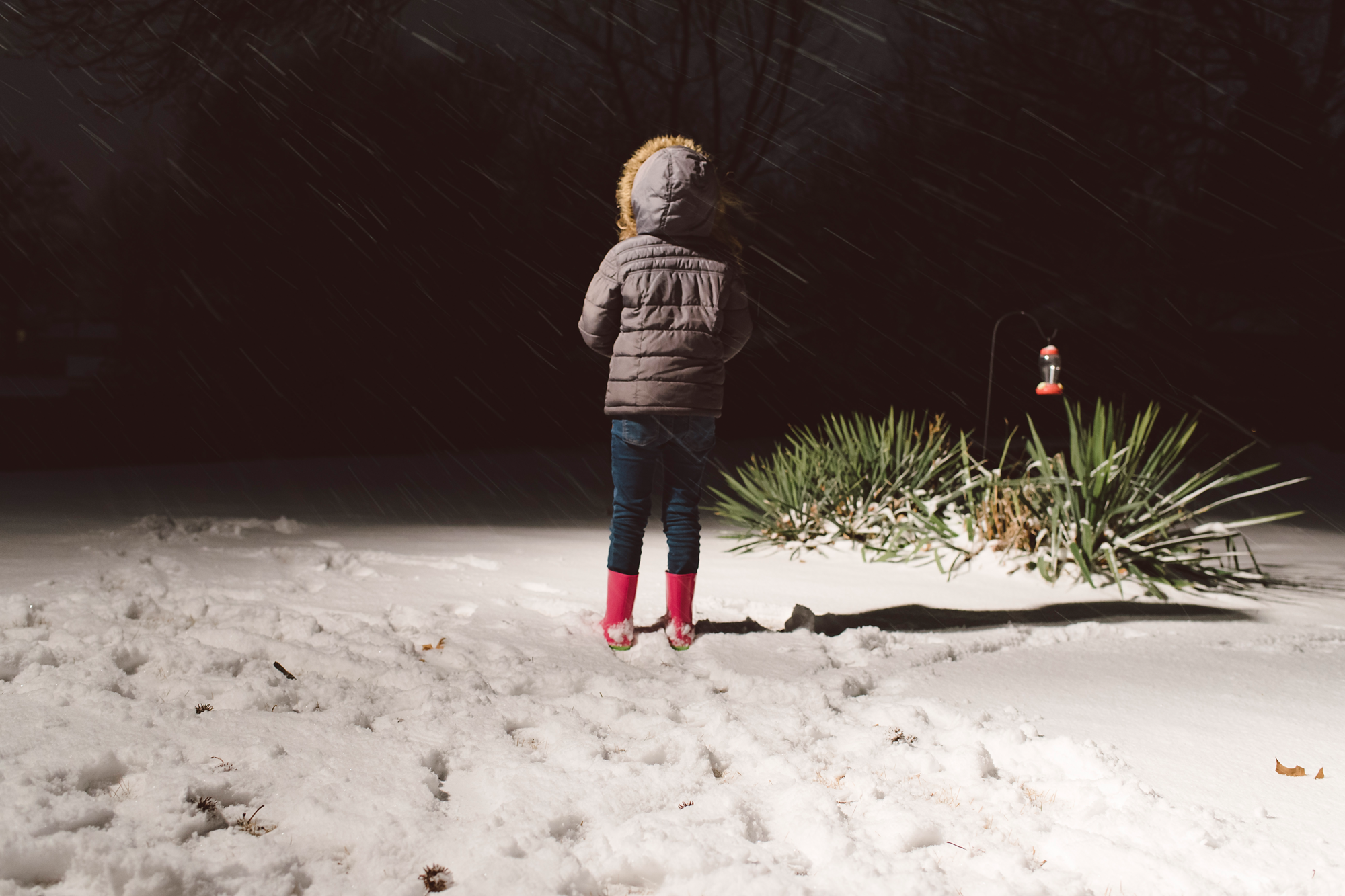Girl standing in snow at night