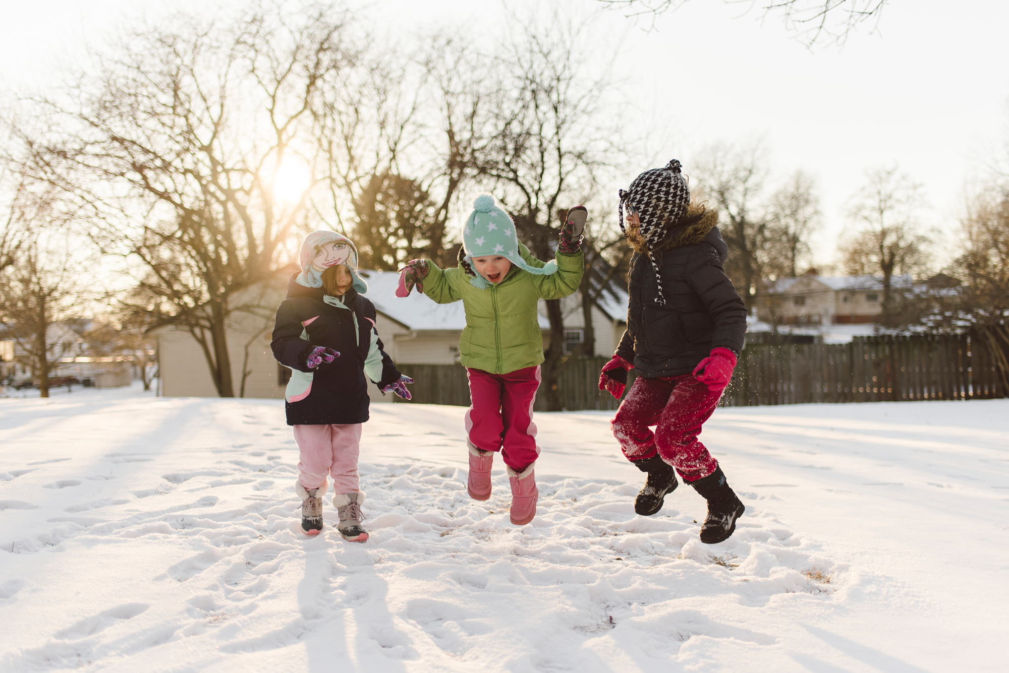 Three girls jumping in the snow