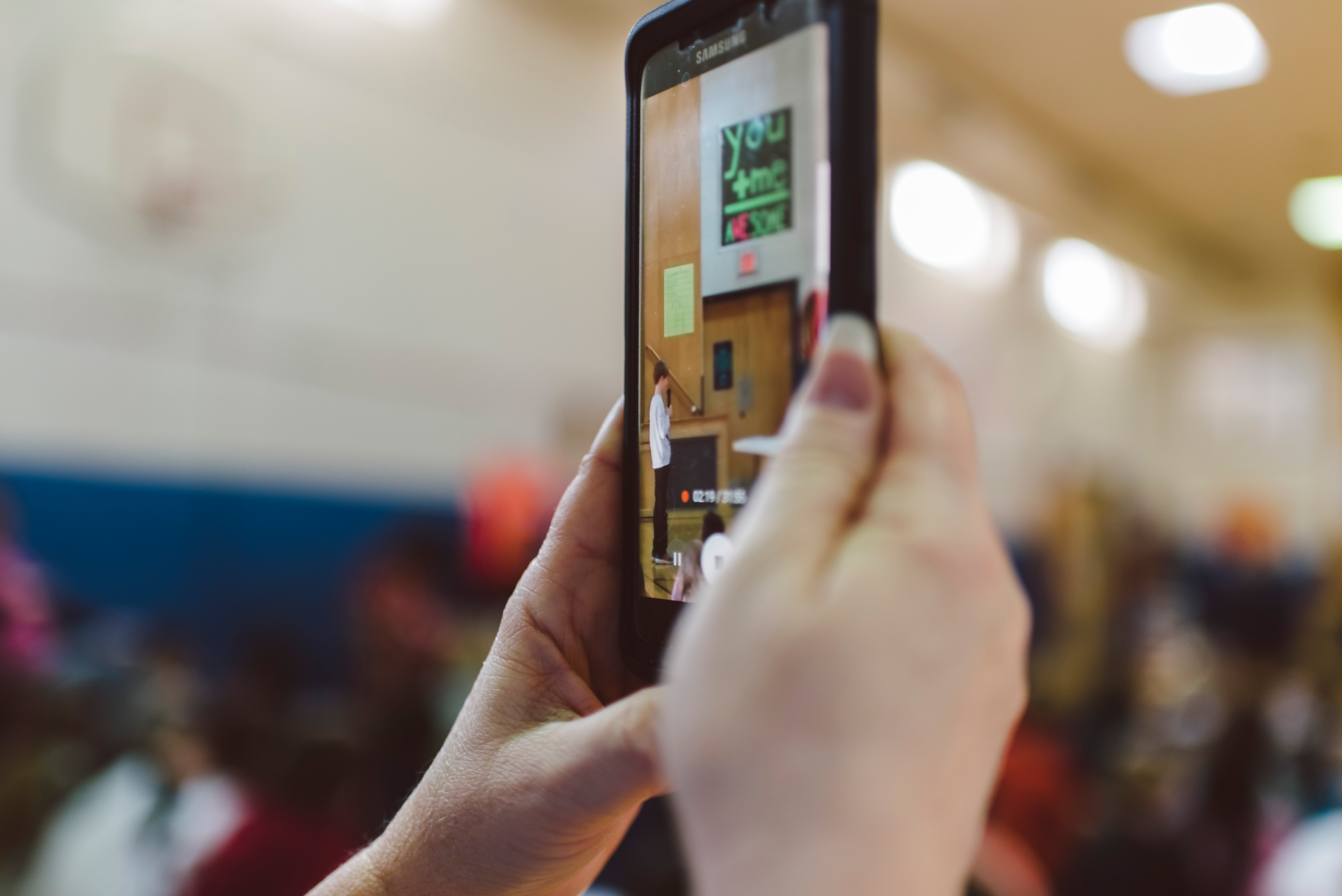 Hand holding phone at spelling bee