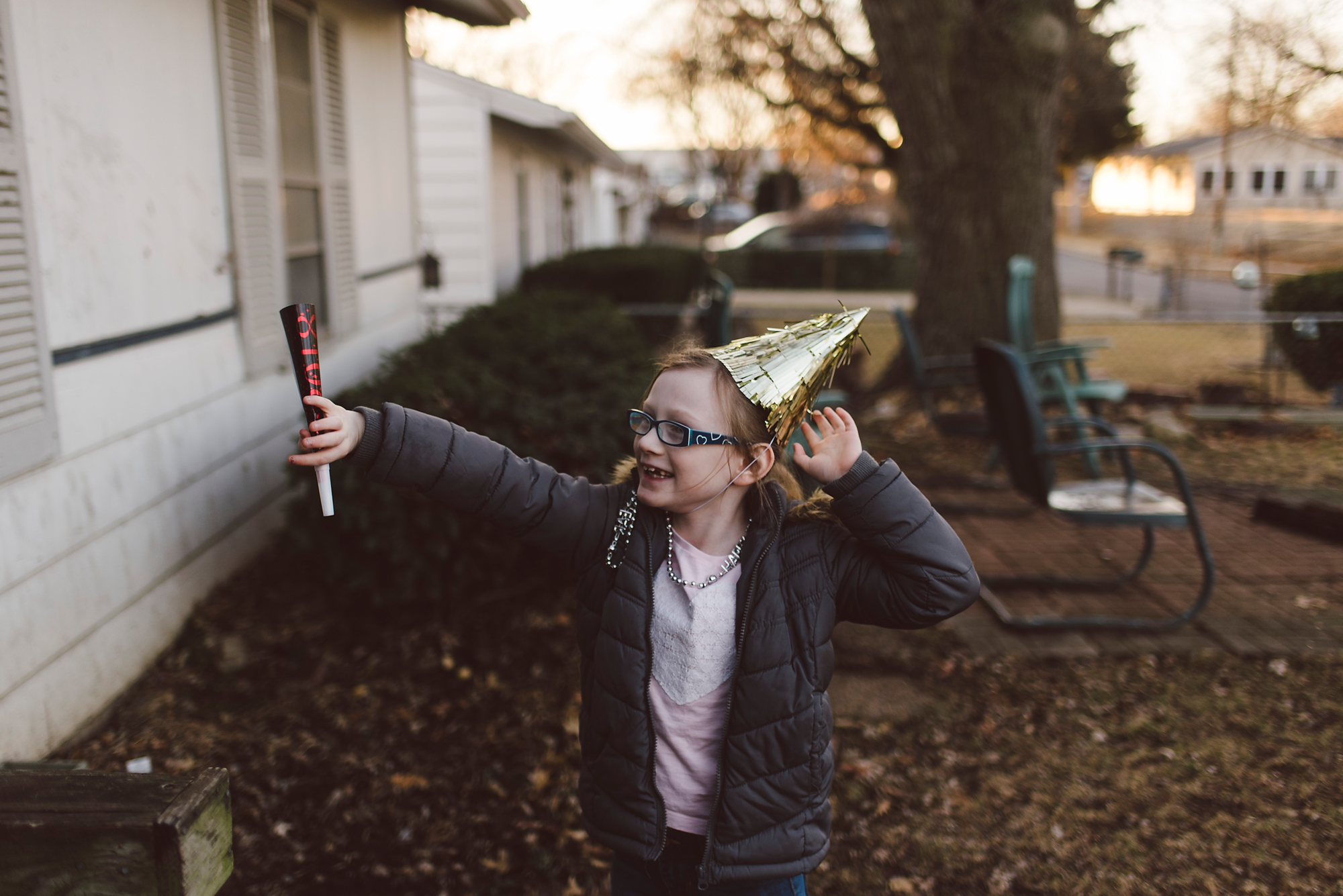 Girl in party hat with arms up
