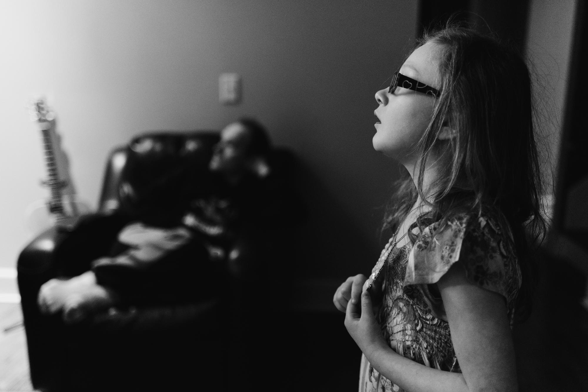 Girl looking at television holding necklace