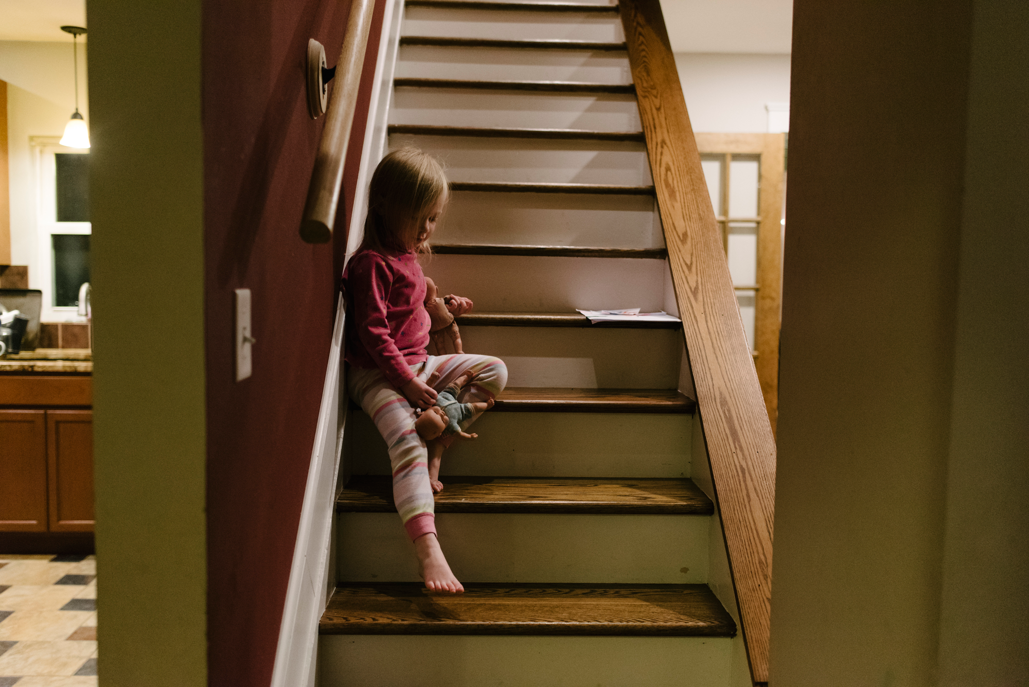 Toddler girl sitting on stairs at night