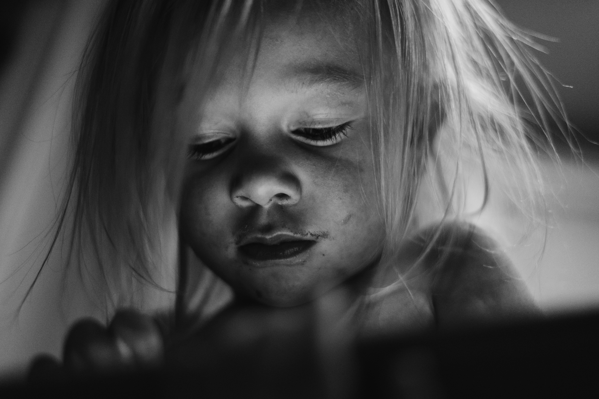 Toddler with dirty face looking at phone