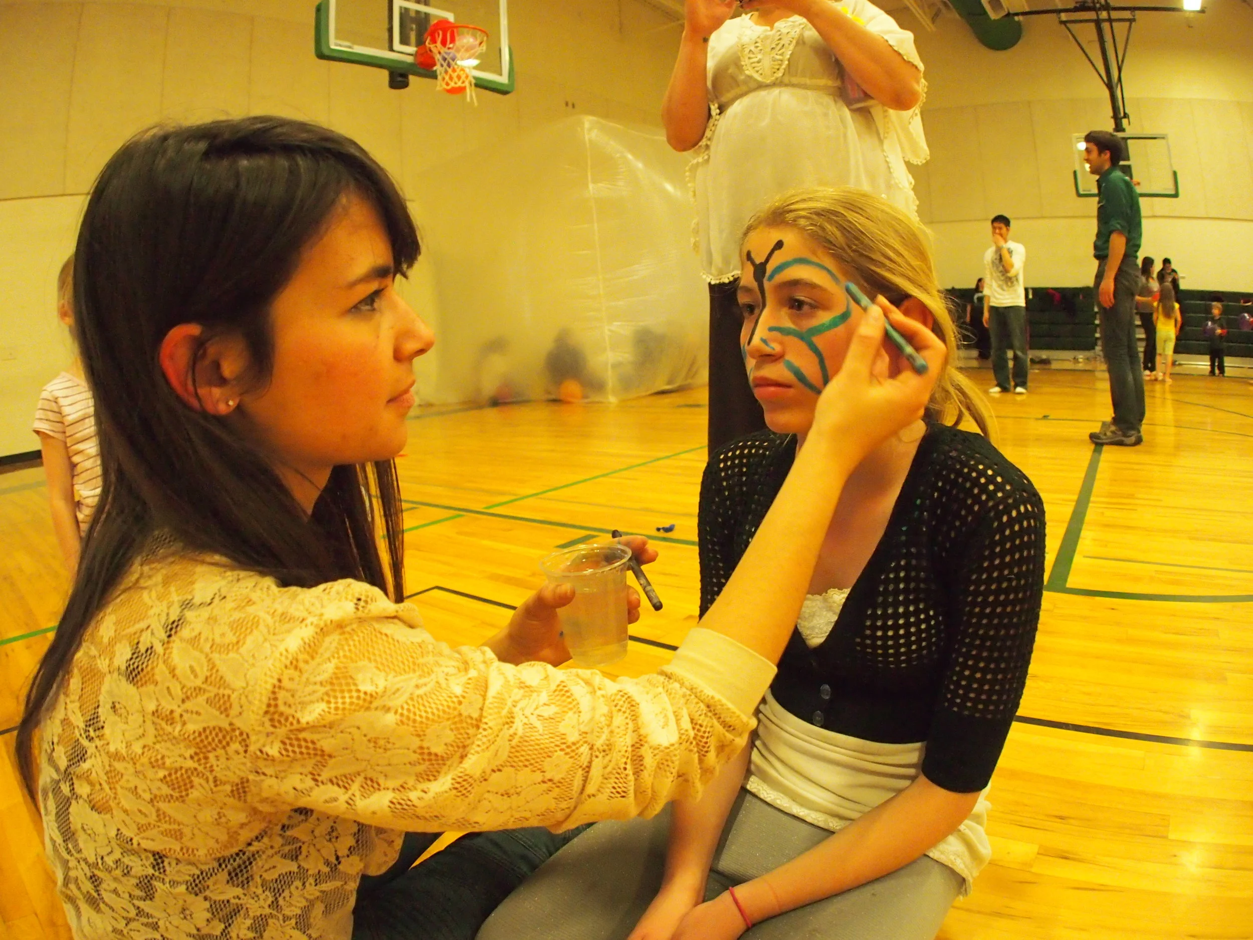 Artist and AmeriCorps VISTA Ashley Ross face-painting at the event.