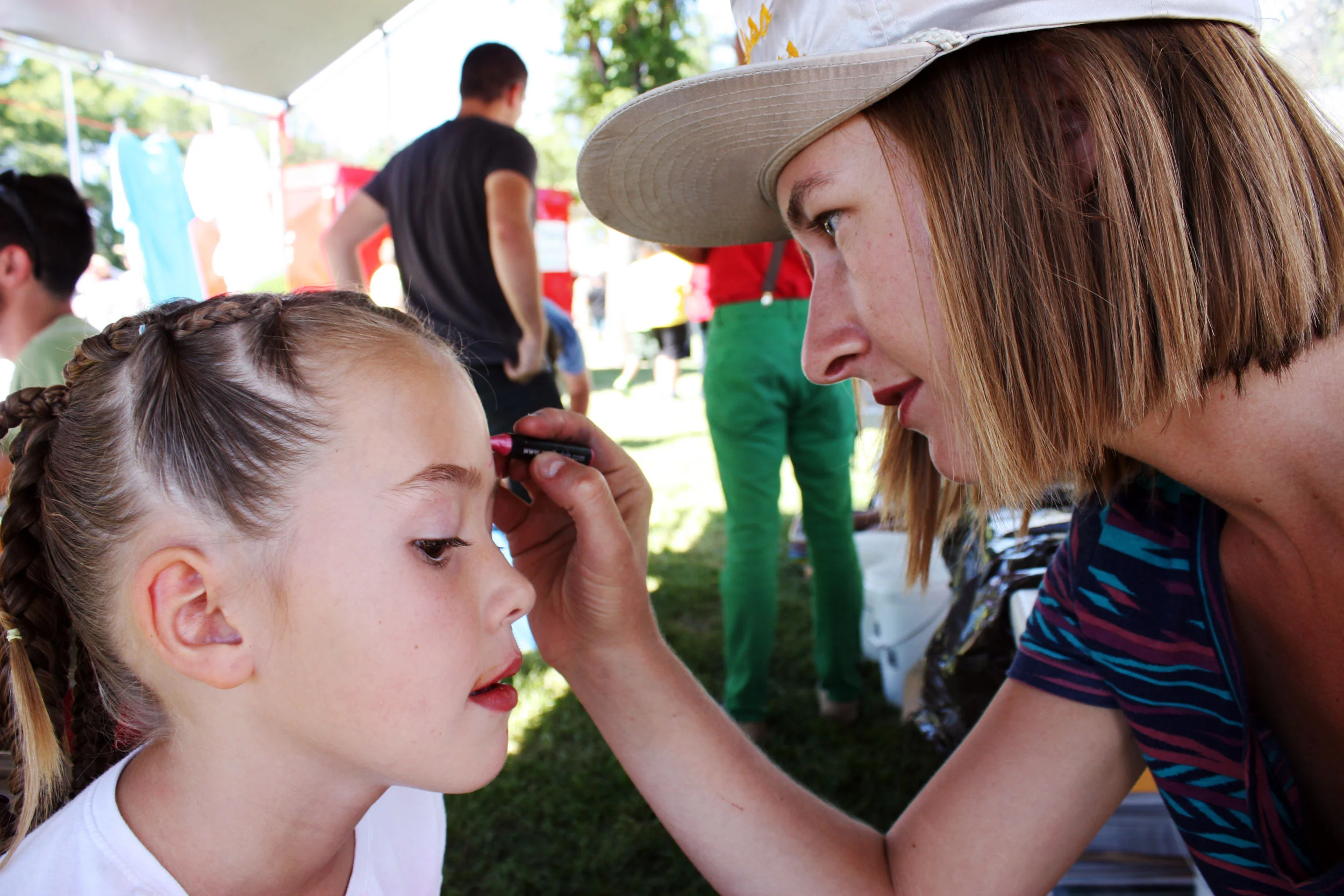 Erica Dixon face-painting at Epicenter's kids arts booth at Melon Days.