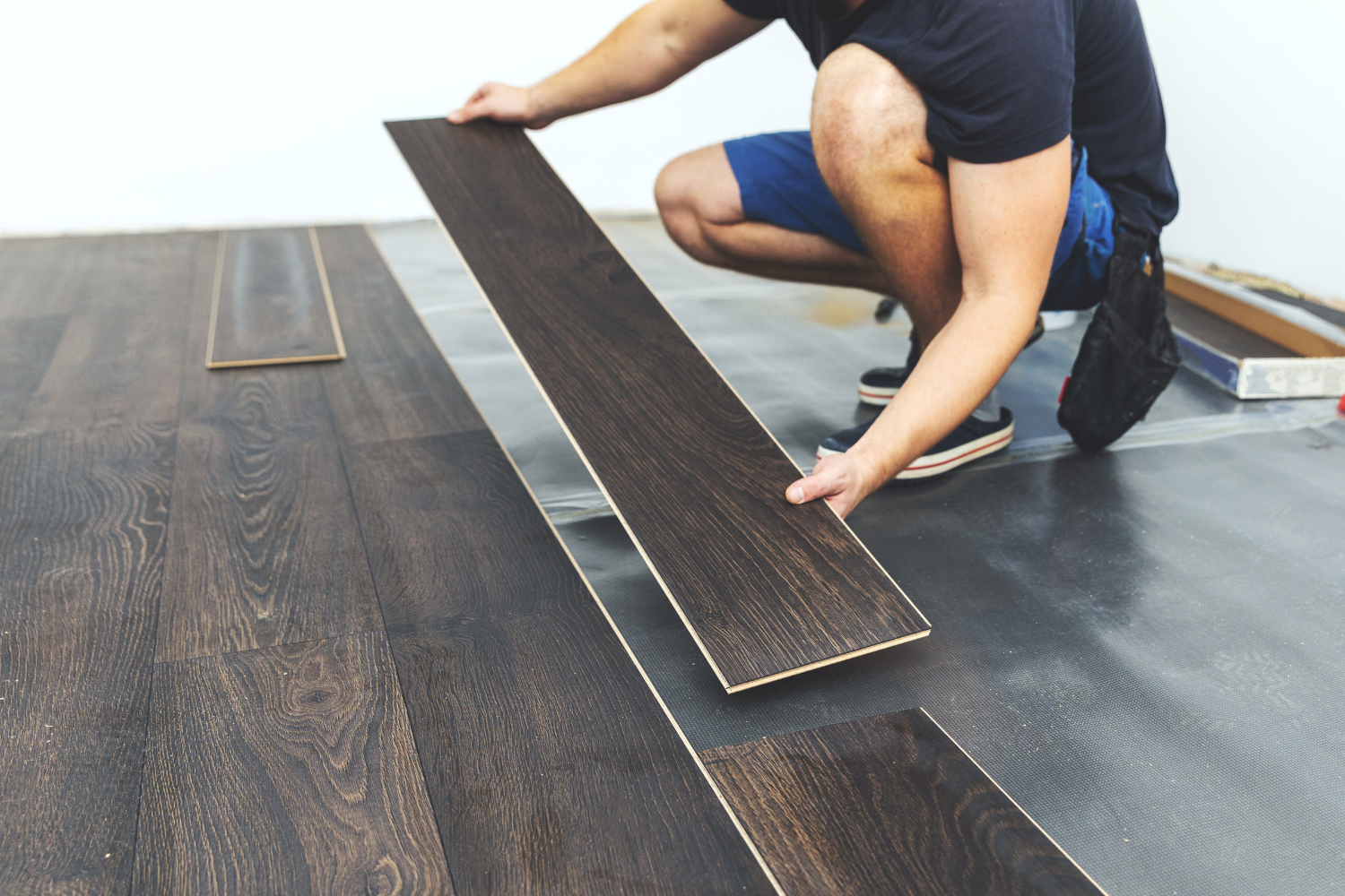 luxury vinyl plank flooring being installed in home by male installer pros and cons lvt vs. lvp flooring in home.png