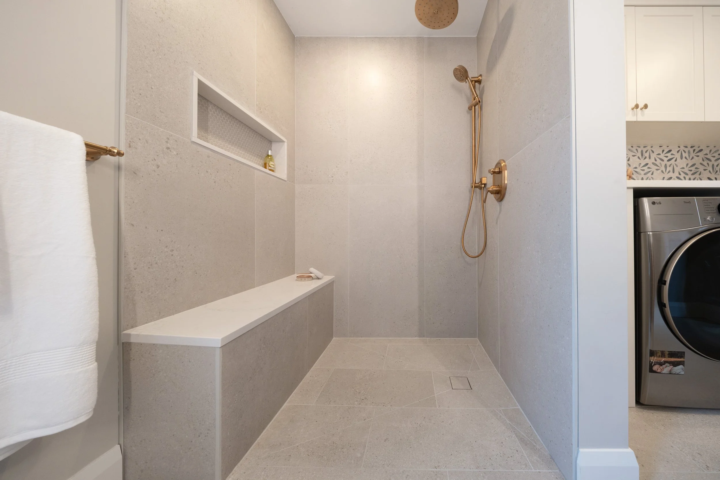 Accessible walk-in shower with no curb, neutral tile, and a seamless, open layout