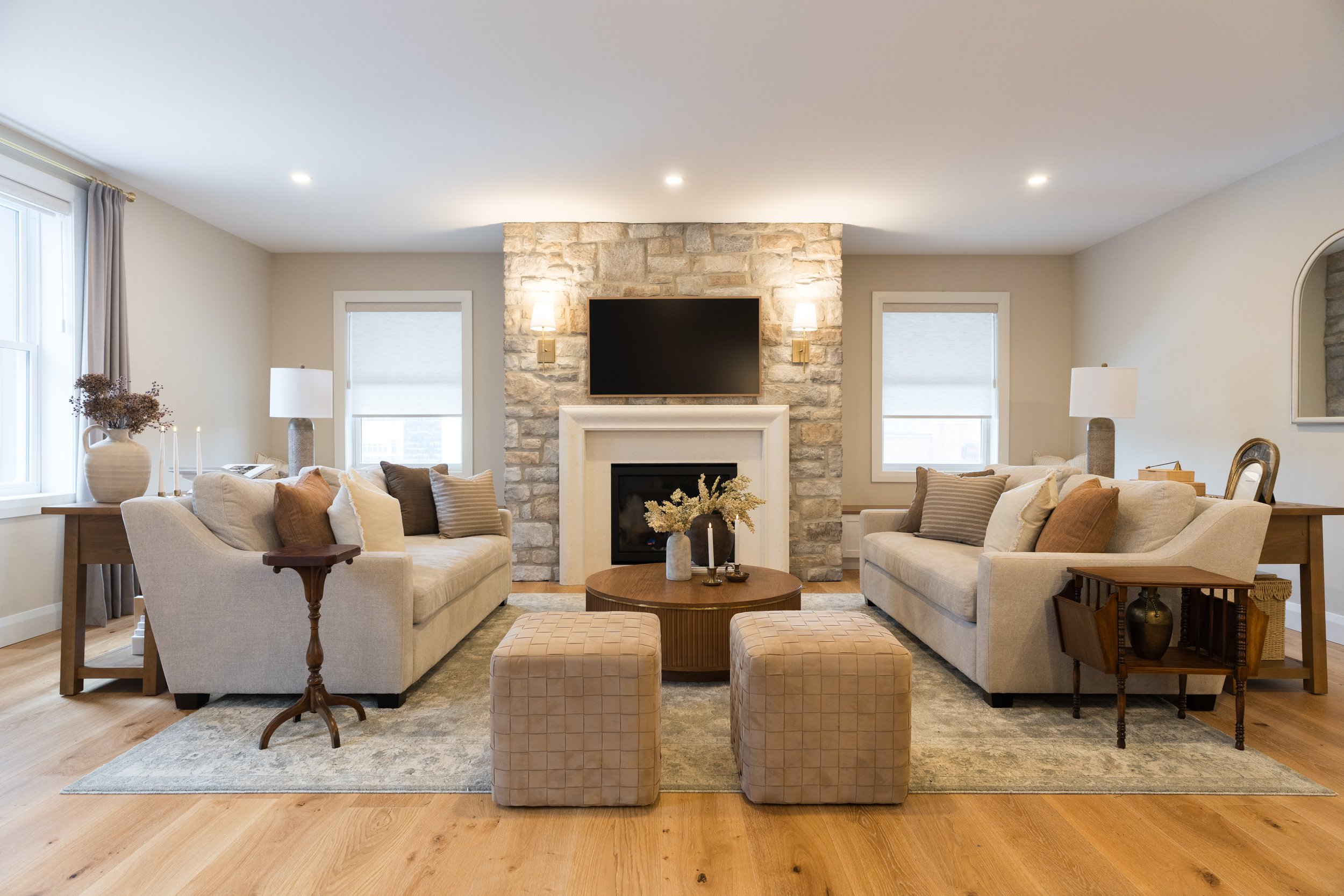 Fireplace detail featuring a cast stone mantle, natural stone surround, and mounted lighting above