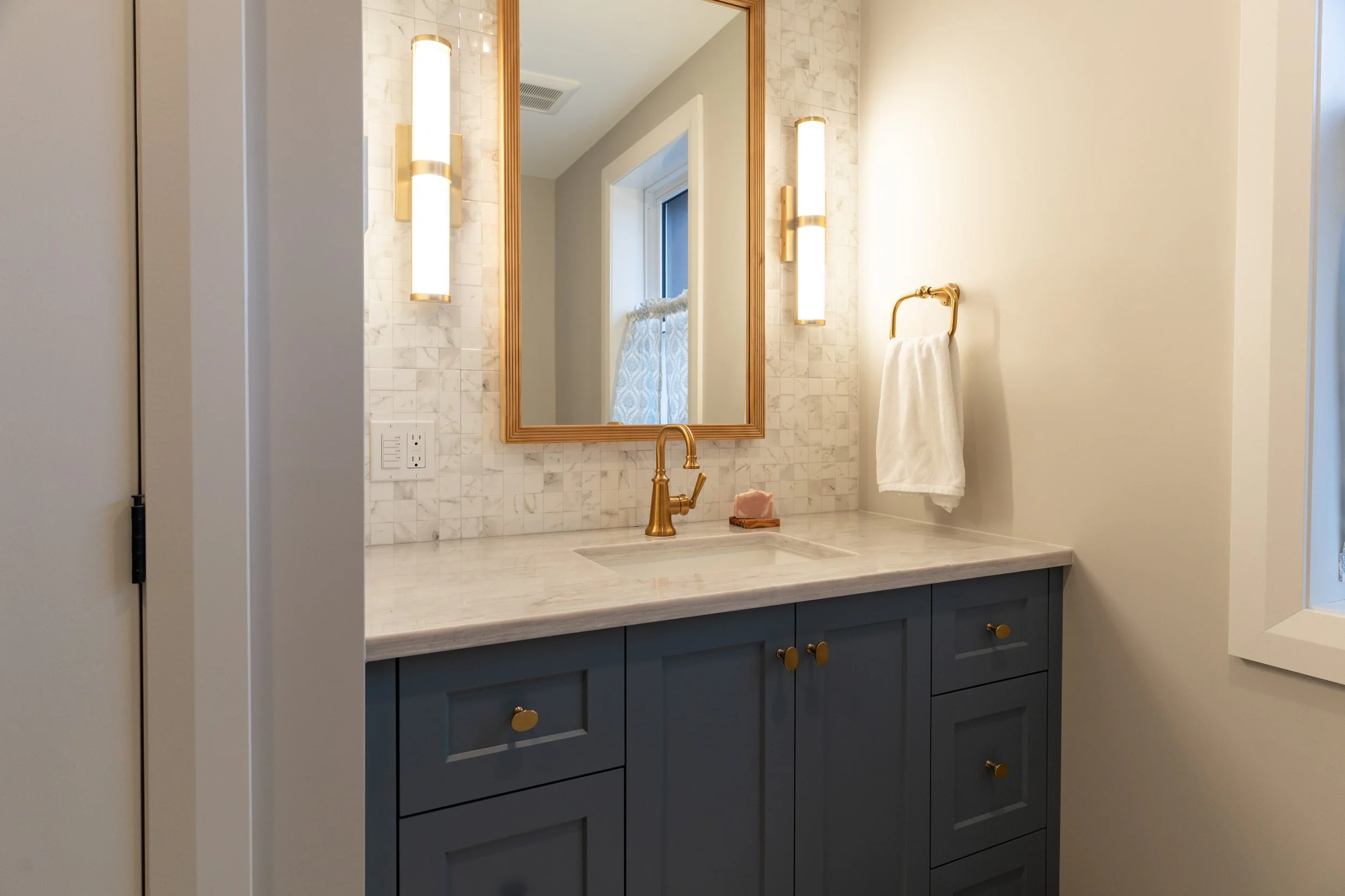 Bathroom and laundry area with blue tile detail and minimal fixtures