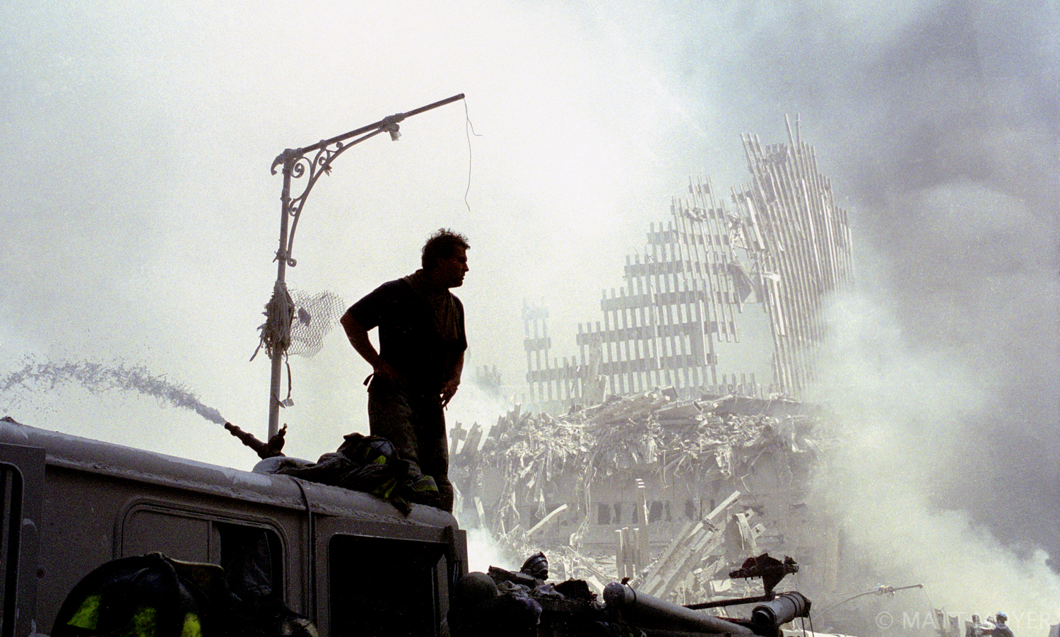  A firefighter stands atop a demolished fire truck at ground zero after the destruction of the World Trade Center on Sept. 11, 2001. 