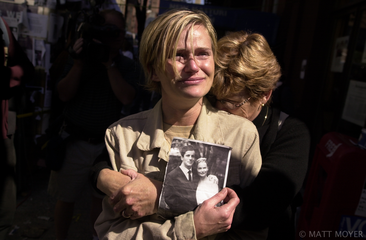  Mary Ortale, left, of Brooklyn, N.Y., holds a picture of herself with her missing husband, Peter while she is hugged by her mother, Kathi Adlum at the 69th Regiment Armory in New York Saturday, Sept. 15, 2001. Ortale's husband has been missing since