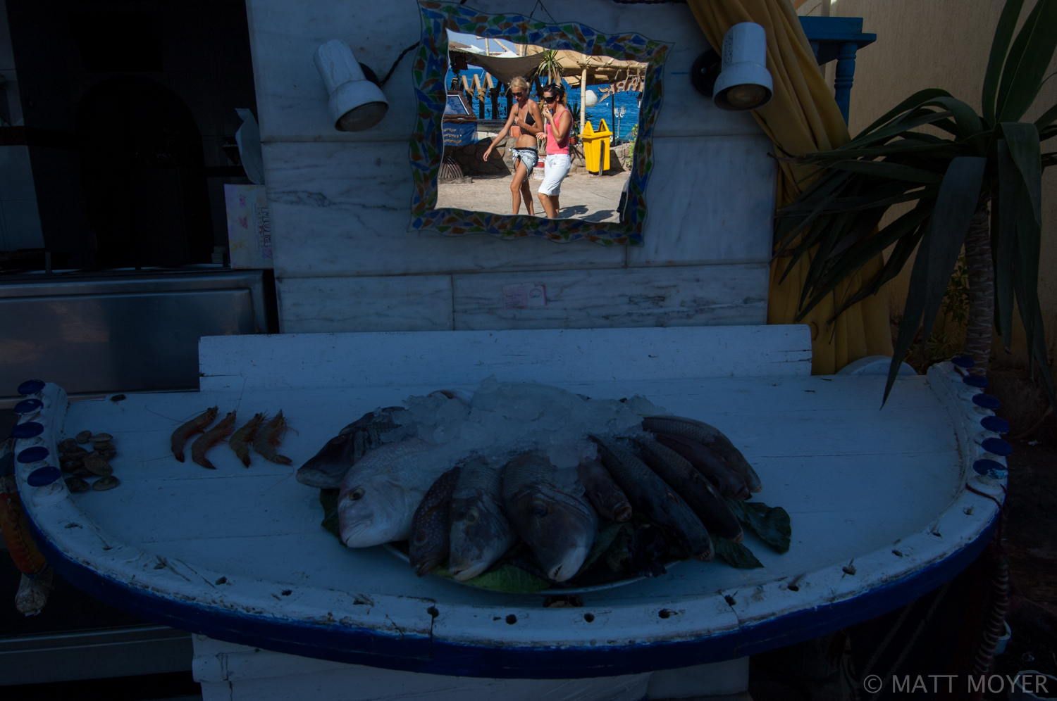  A mirror reflects passersby in Dahab, Egypt. 