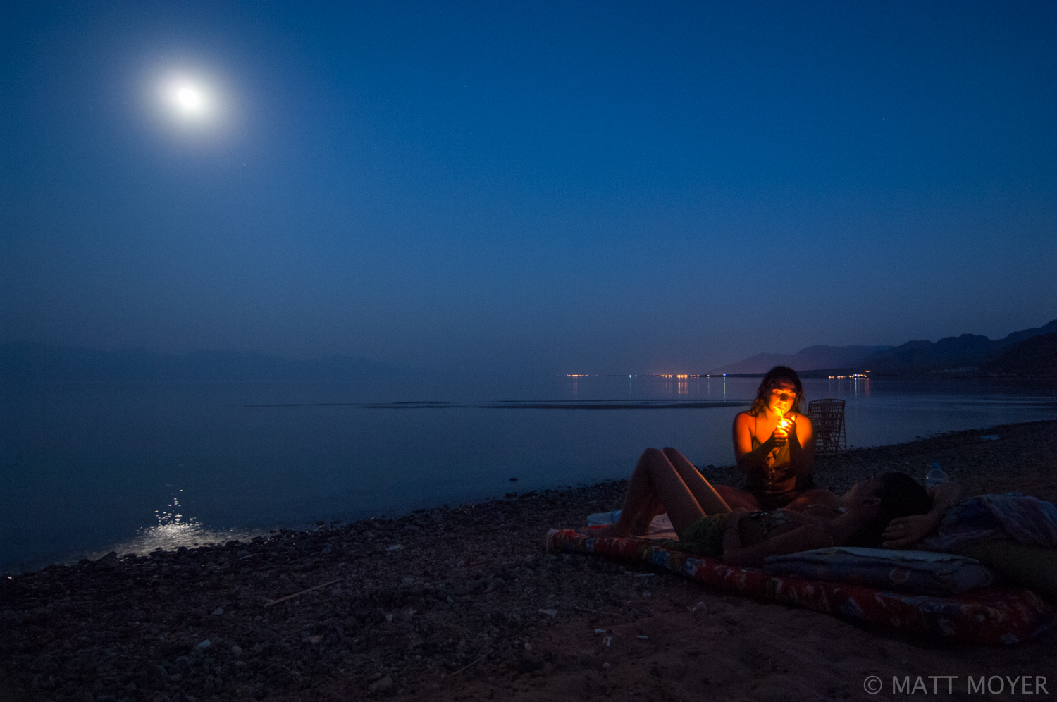  Hayley Shtienberg, 22, lights a cigarette with her friend Eilat Zukerman, both of Eilat, Israel while watching the moon rise over the Gulf of Aquba near Nuweiba, Egypt. 