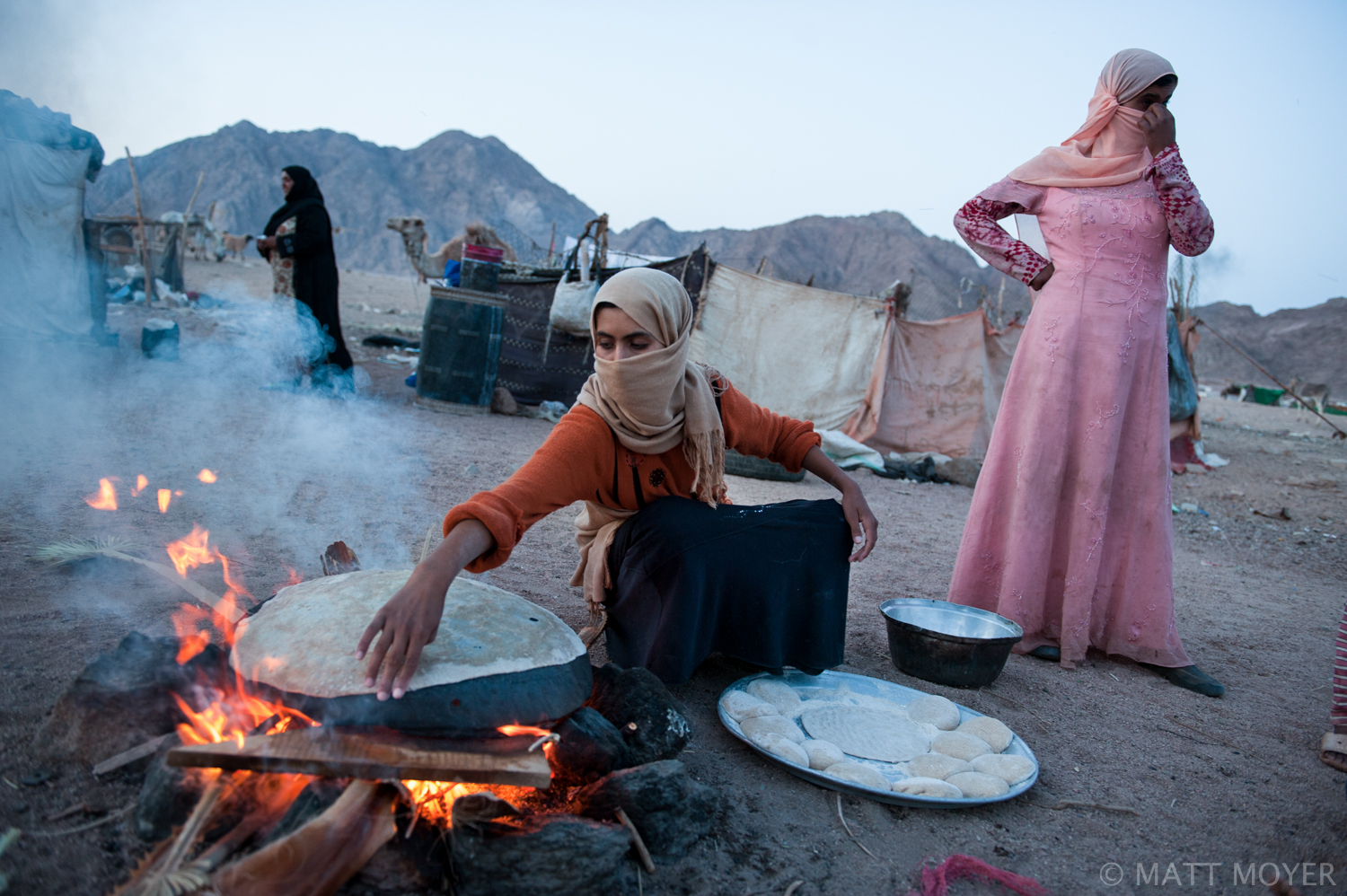  Bedouin women make bread over an open fire. The bedouin live in a makeshift squatter camp near a garbage dump on the outskirts of Sharm El Sheikh. A seven year drought has forced the bedouin down from their traditional mountain homes. Discrimination