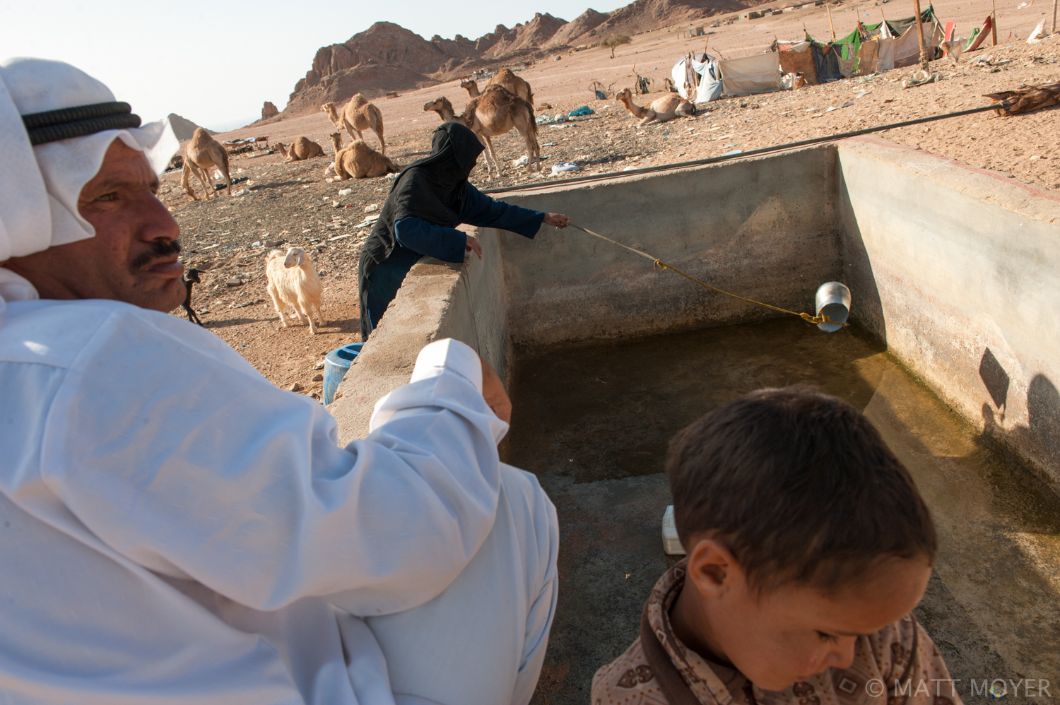  A bedouin woman throws a can to collect water from a cistern in the squatter camp she lives in. The bedouin live in a makeshift squatter camp near a garbage dump on the outskirts of Sharm El Sheikh. A seven year drought has forced the bedouin down f