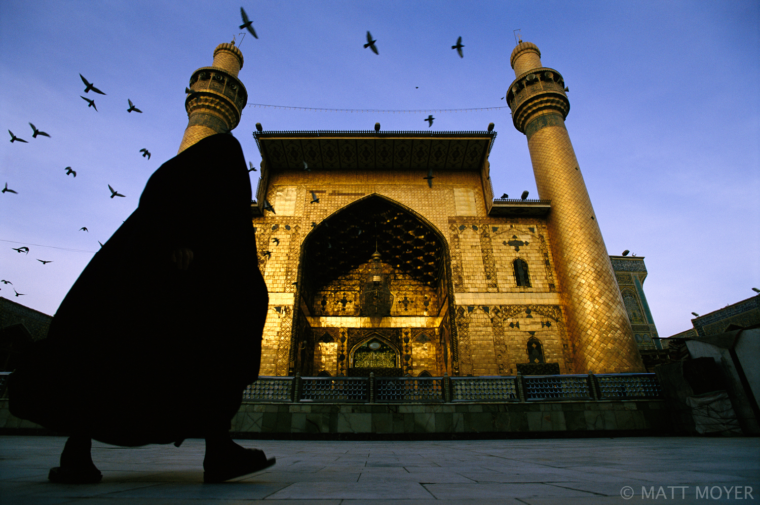  A Shiite woman walks in front of the Imam Ali shrine as dawn breaks in Najaf, Iraq. The shrine will soon fill with worshipers taking part in morning prayers. 