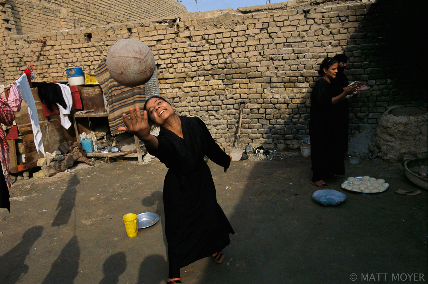  Noel Abdel Wahid, 14, plays ball as her mother and sister make bread in the courtyard behind their home in the sprawling Shiite slum of Sadr City in Baghdad, Iraq. The Wahid family lives in a two-room house without plumbing and they have not been ab