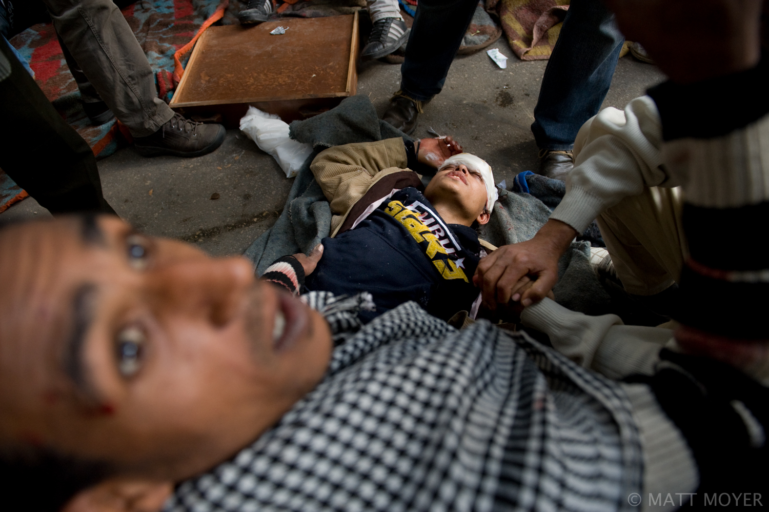  An Egyptian protester is assisted at a makeshift field hospital after being injured in clashes with government forces in Cairo, Egypt. 