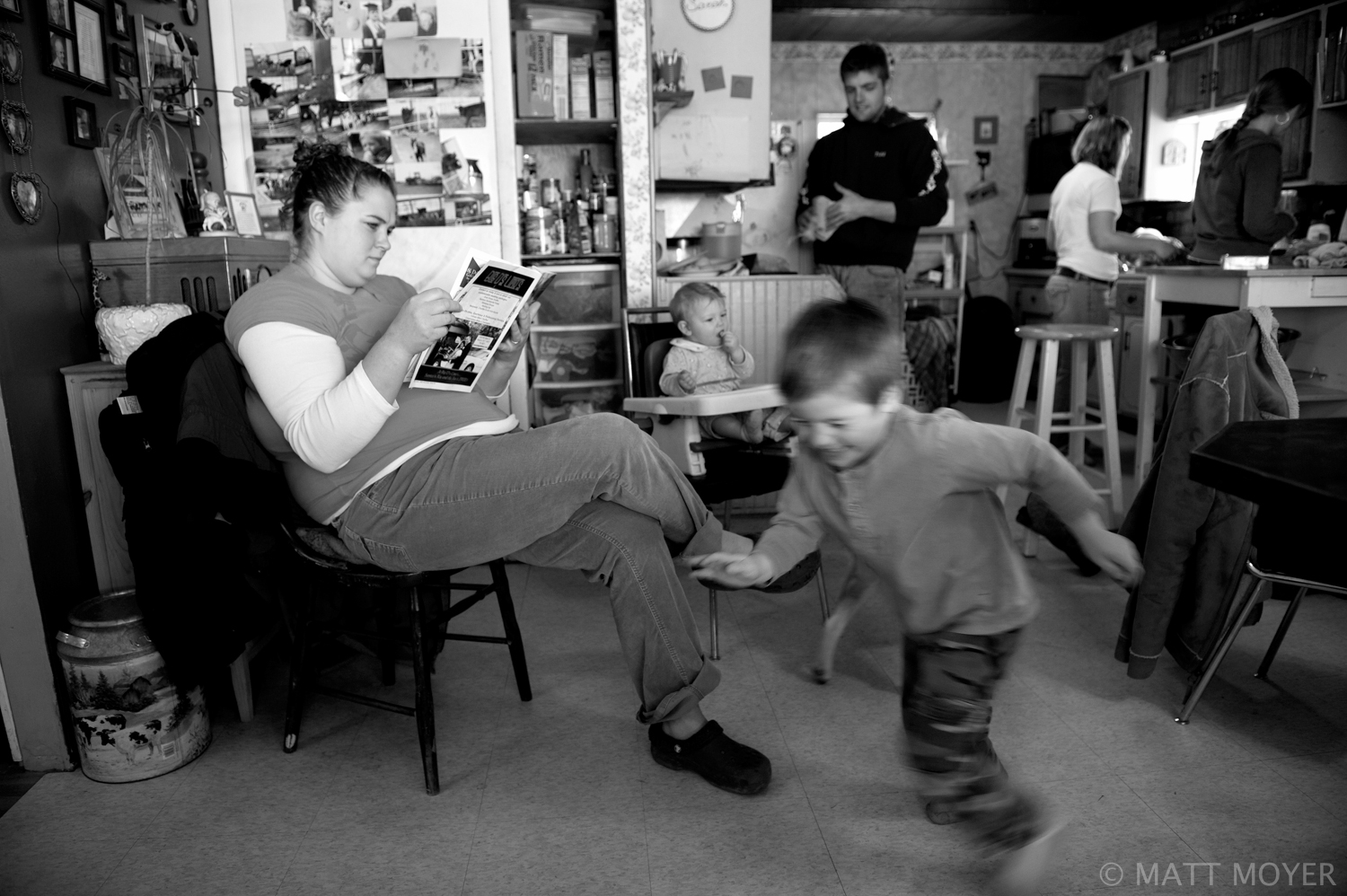  Jen Tidd reads as her son, AJ, 4, plays at the Tidd homestead in Auburn, NY. Jen's husband, Ed Tidd, runs a small dairy operation with his father Joe Tidd. 