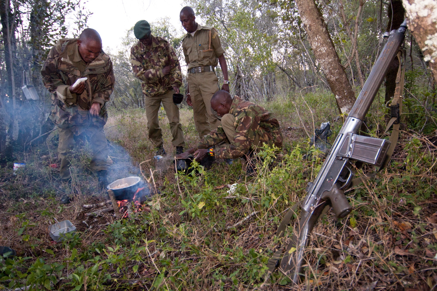  Members of an anti-poaching unit prepare dinner at their camp before patrolling a wildlife park in Lewa Downs, Kenya. 