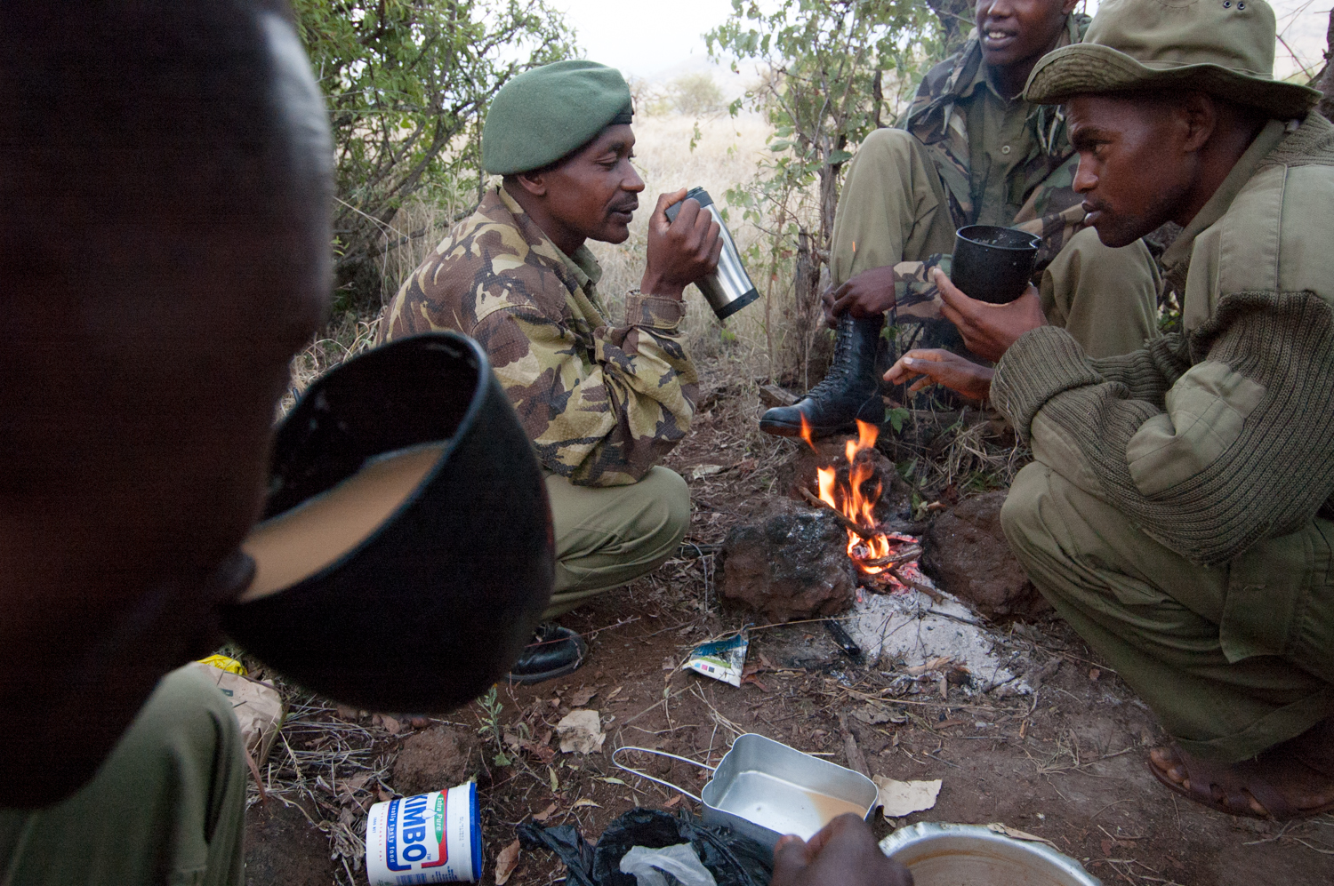  Members of an anti-poaching unit relax by a camp fire after a morning patrol at a wildlife park in Lewa Downs, Kenya. 