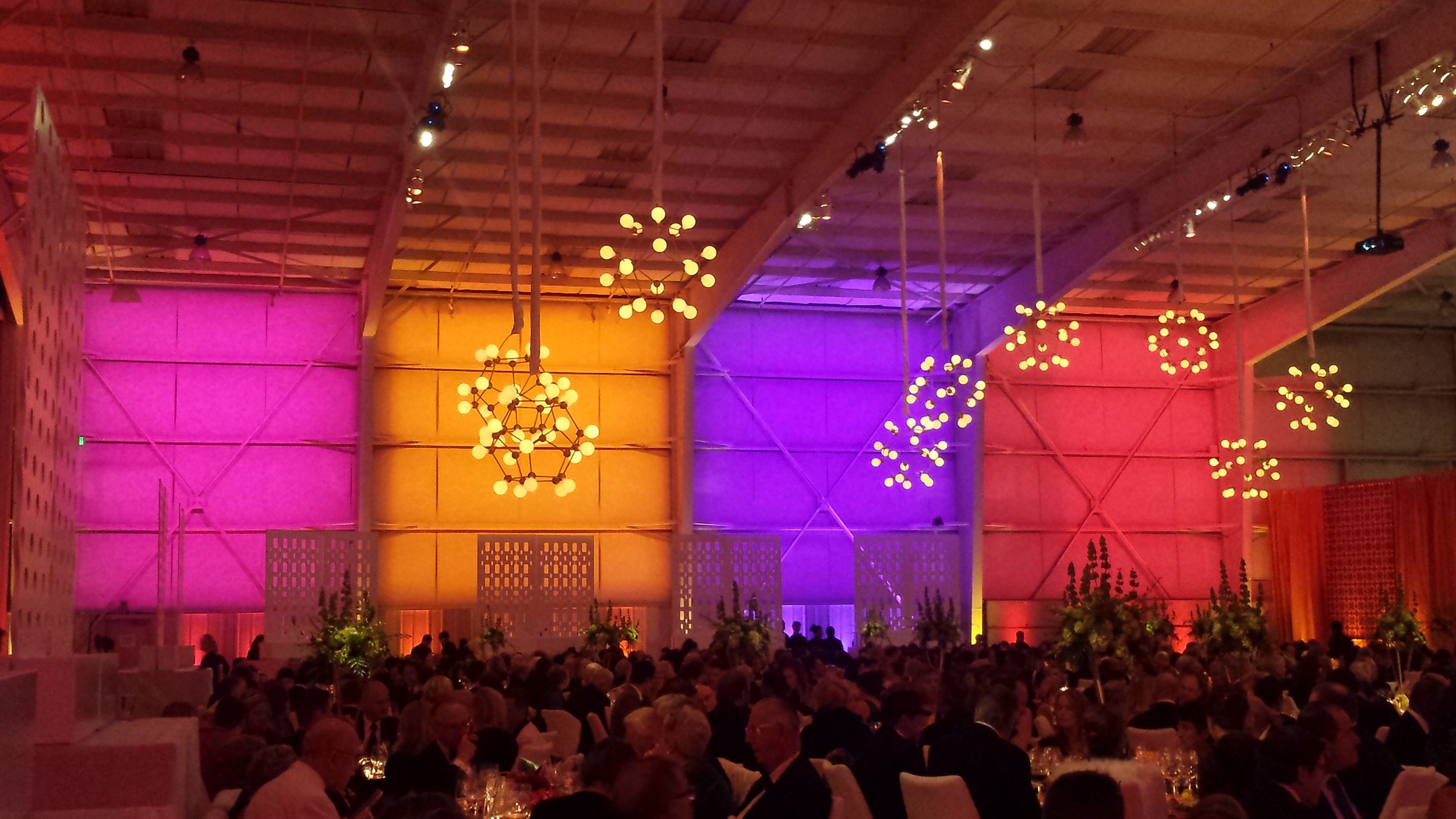 This airplane hangar is transformed into a festive party through the use of color and light.