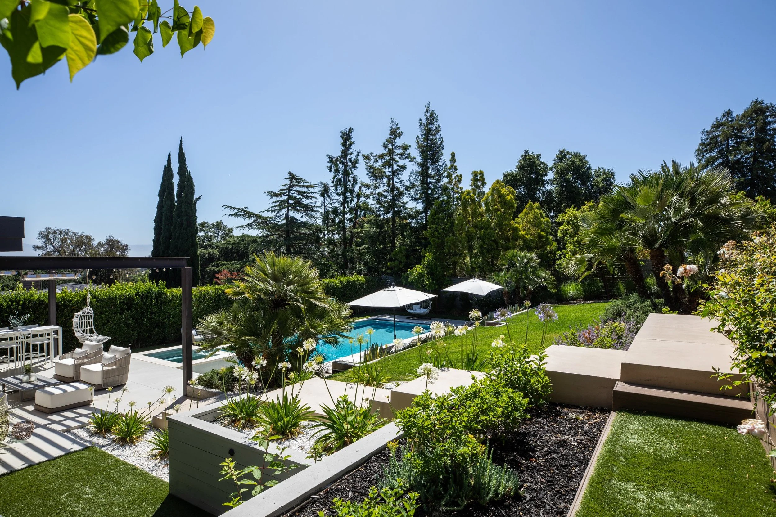 Terraced gardens stepping down to the pool and outdoor lounge, modern home in Los Altos, CA