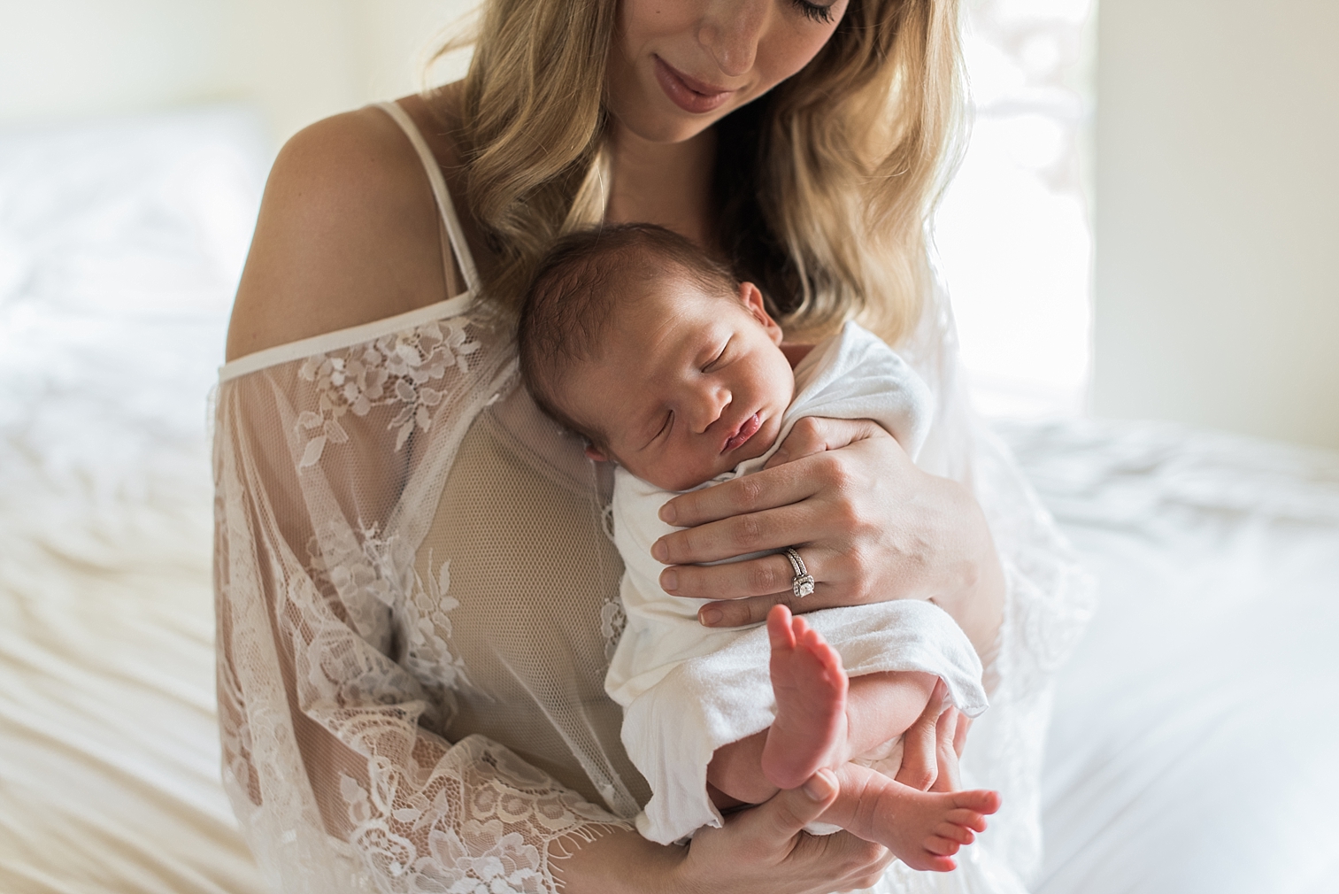  mom holds her baby while gazing down at him 