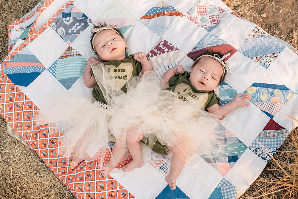  twin baby girls lay on a vintage quilt at smith rock, oregon 