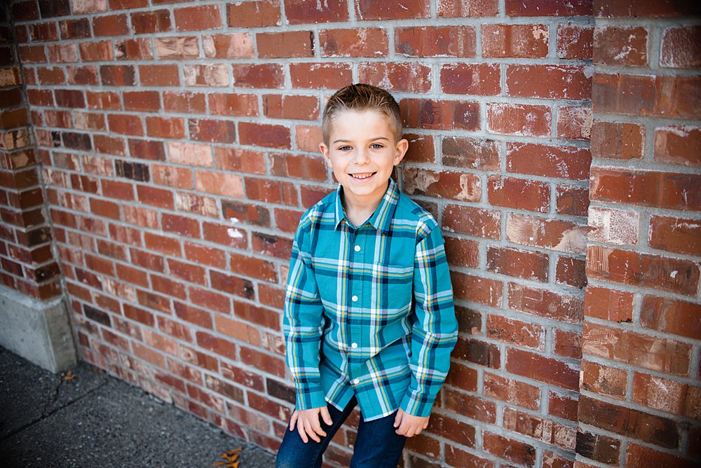  a close up of a boy posing in front of a brick wall in Bend Oregon 